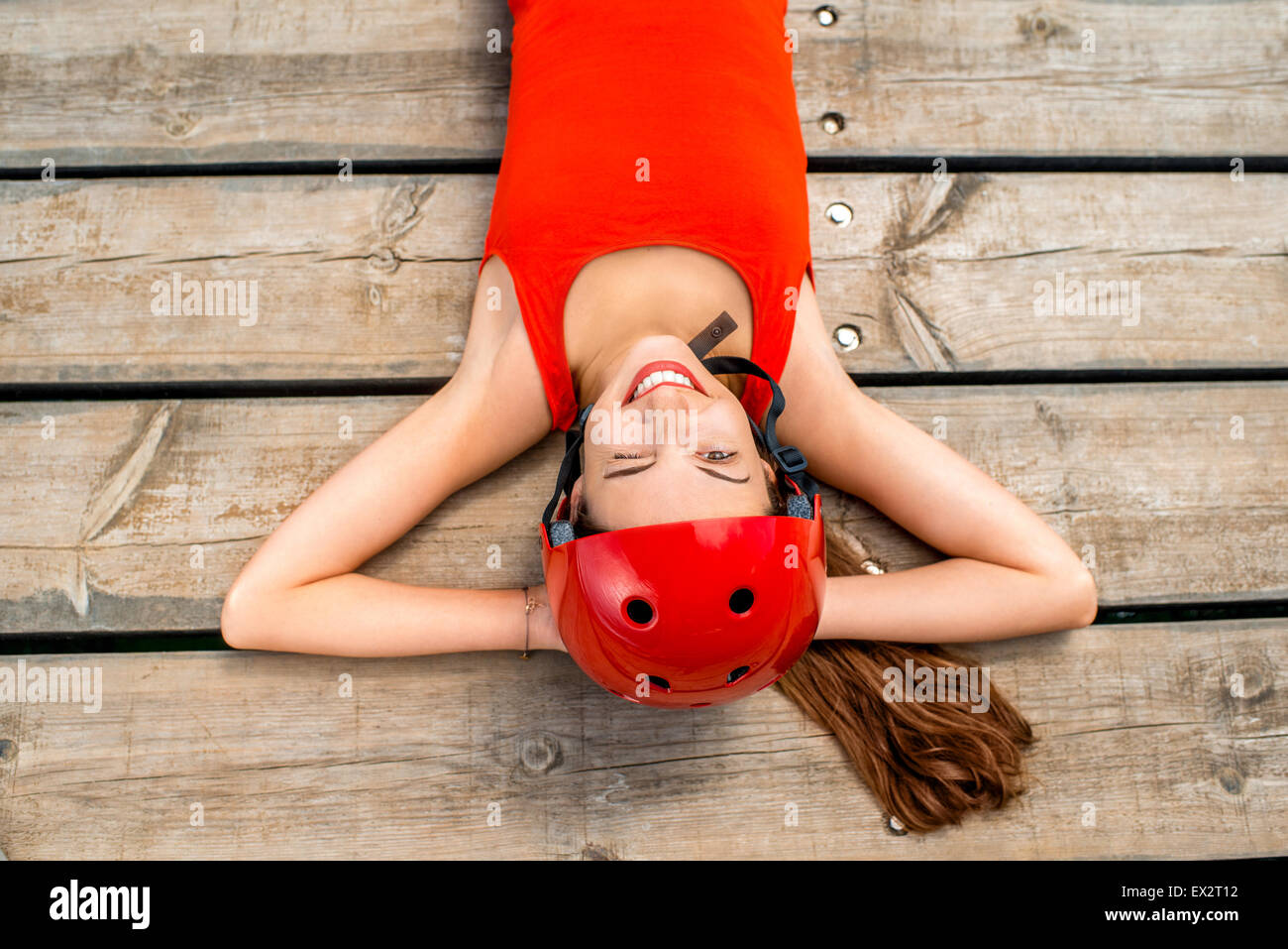 Donna in abbigliamento sportivo in appoggio su assi di legno Foto Stock