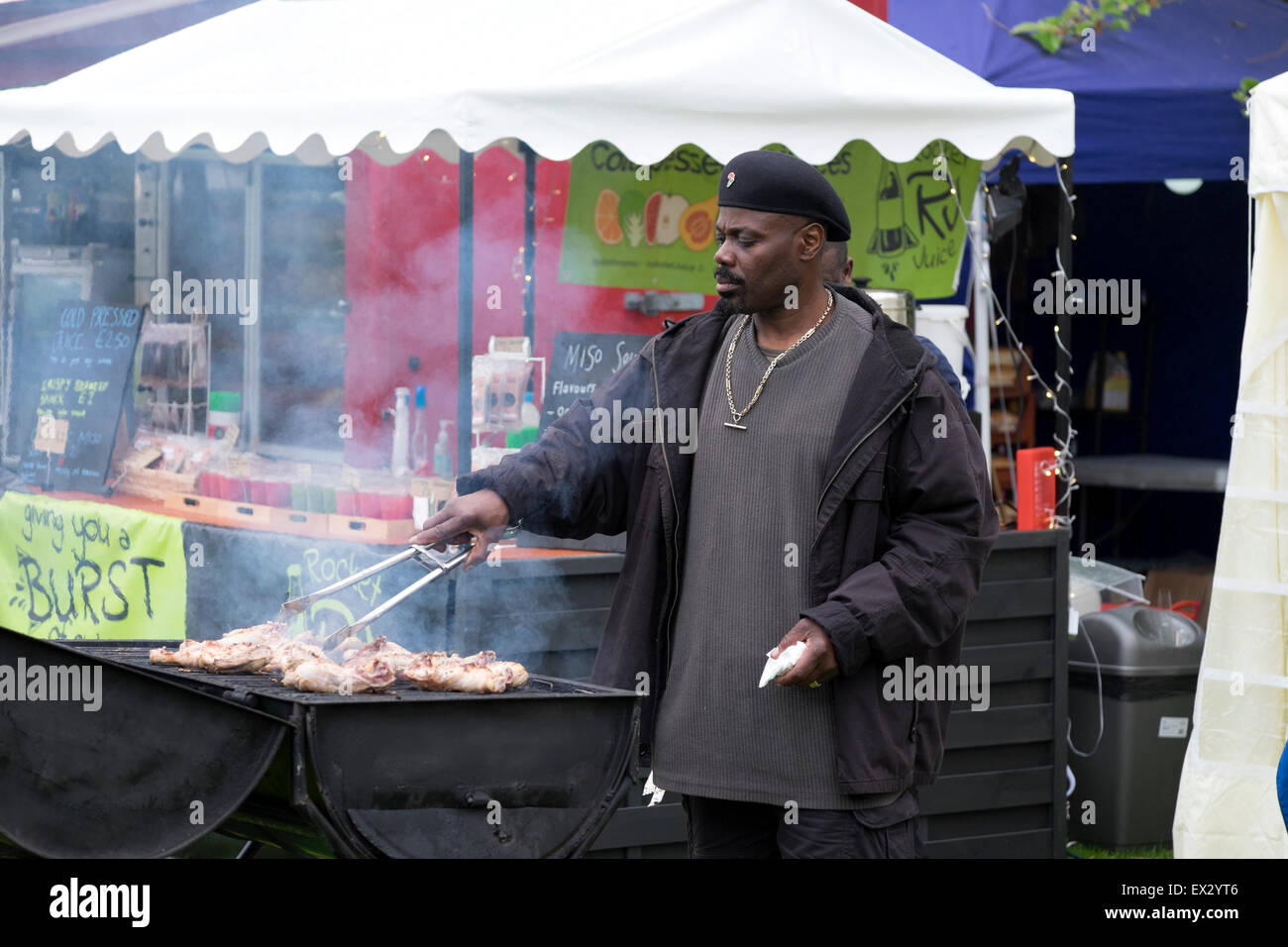 Afro-caraibica uomo africano di cottura di pollo BBQ Foto Stock