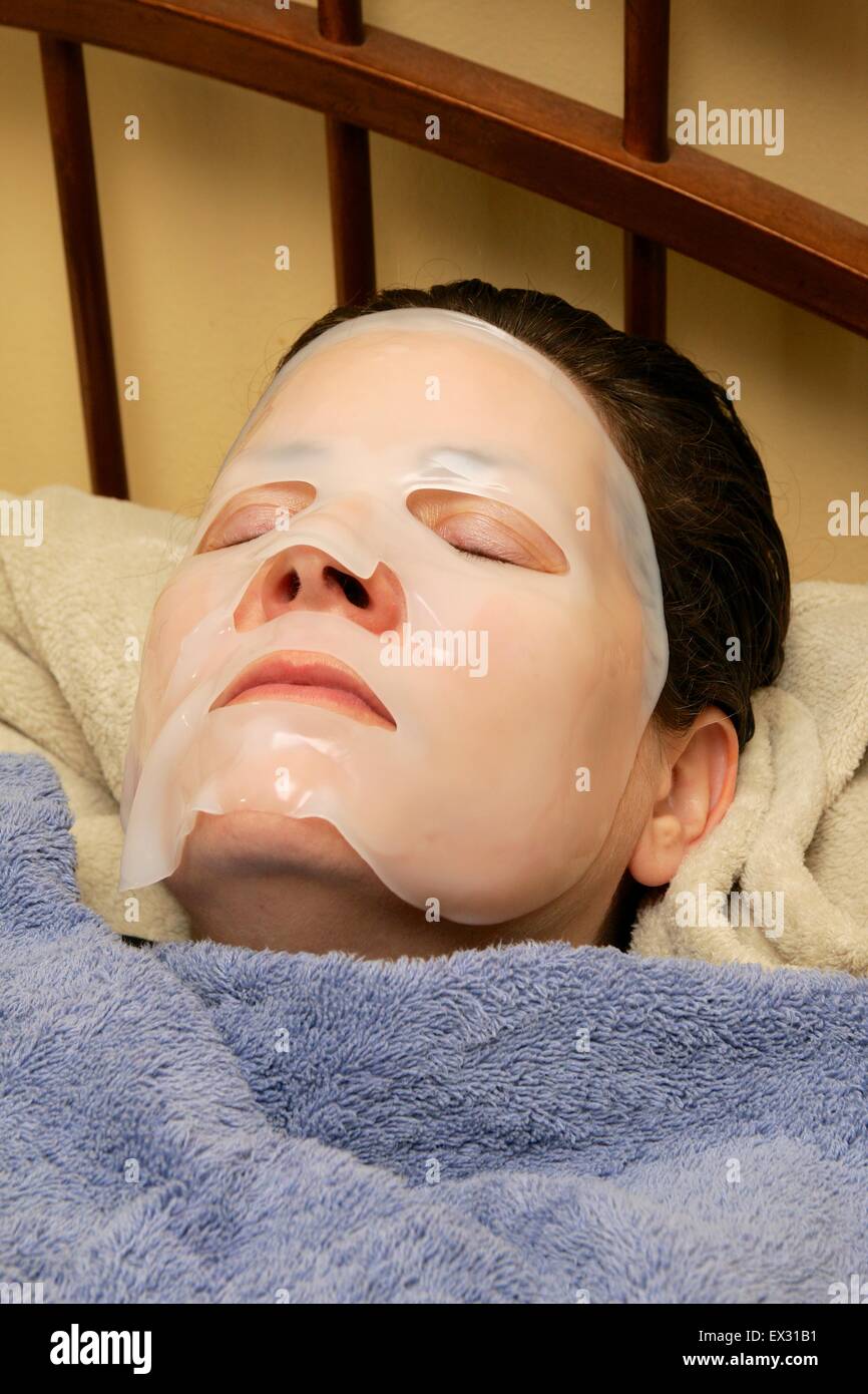 Donna che indossa viso/skin care maschera. Foto Stock