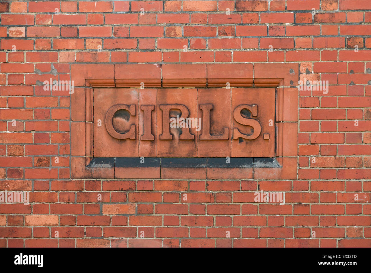 Ragazze segno scritto in mattone sul lato di un edificio scolastico. Foto Stock