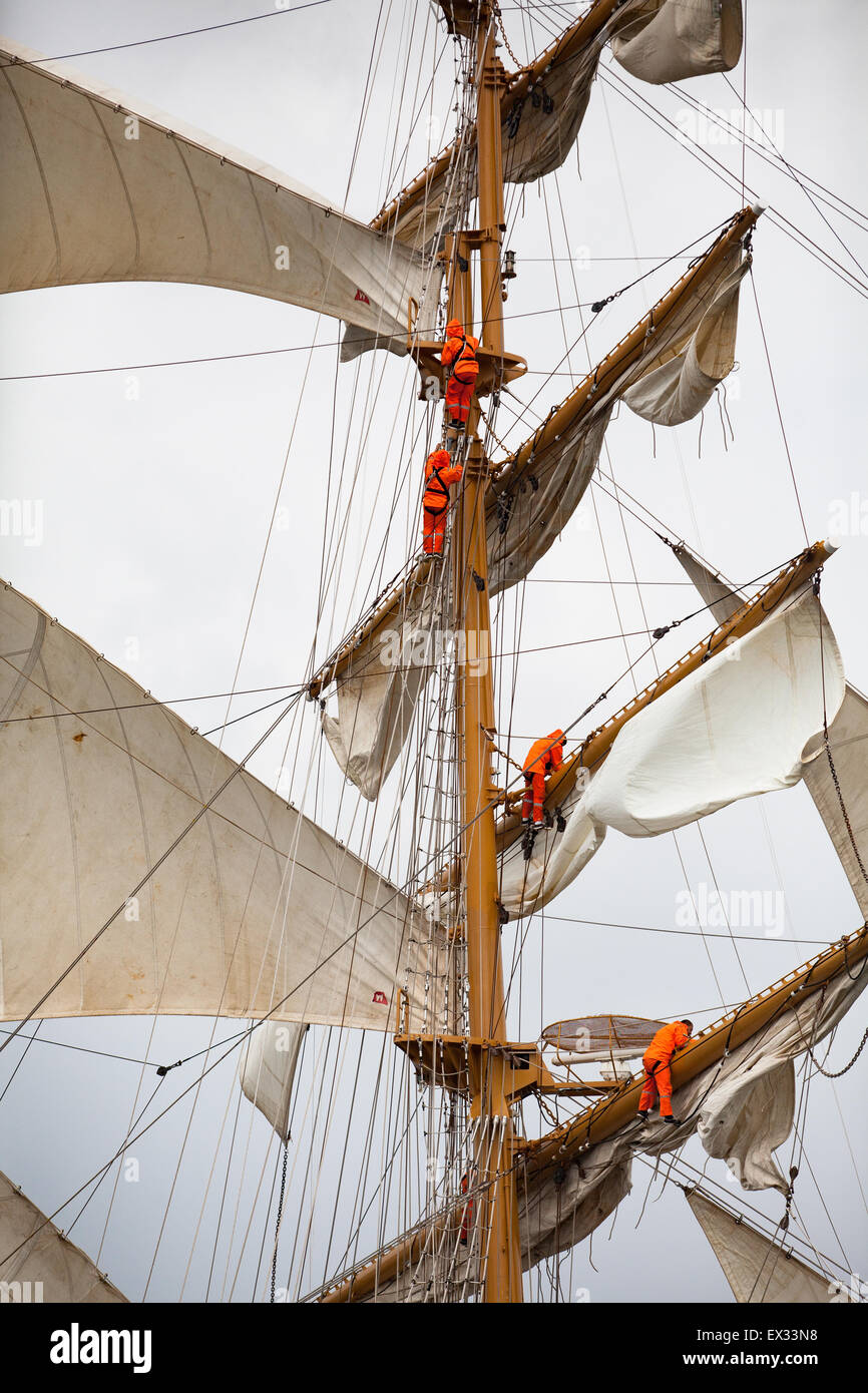 Belfast, Regno Unito. 4 luglio 2015. Gran partenza di Tall Ships del Titanic Festival marittimo membri di equipaggio dalla nave ecuadoriano Guayas aprendo le vele come la nave lascia Belfast Lough Credito: Bonzo Alamy/Live News Foto Stock
