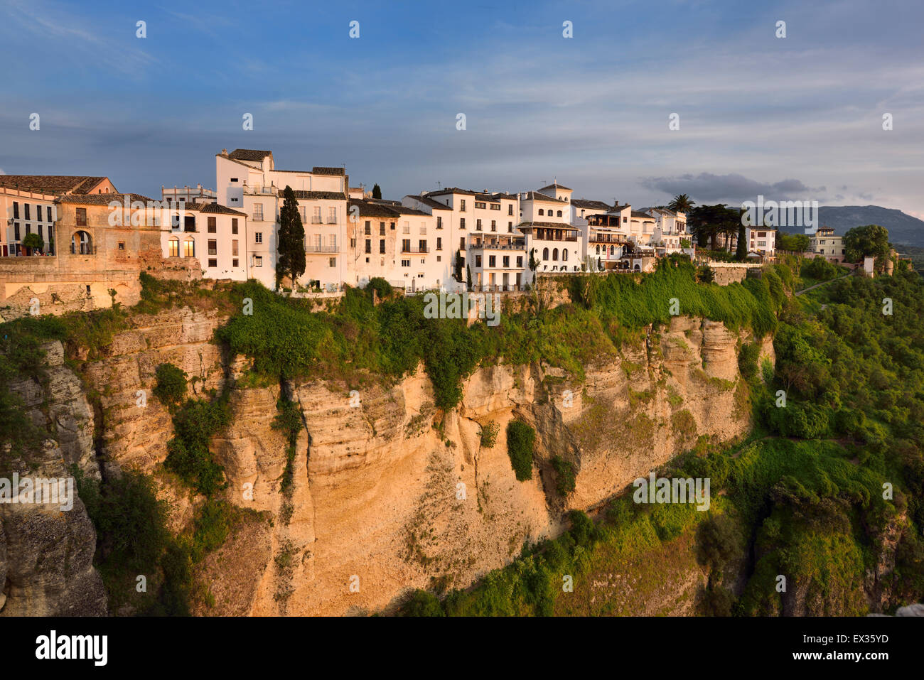 Sole di sera su edifici di colore bianco e arancione scogliere a El Tajo Gorge Ronda Spagna Foto Stock