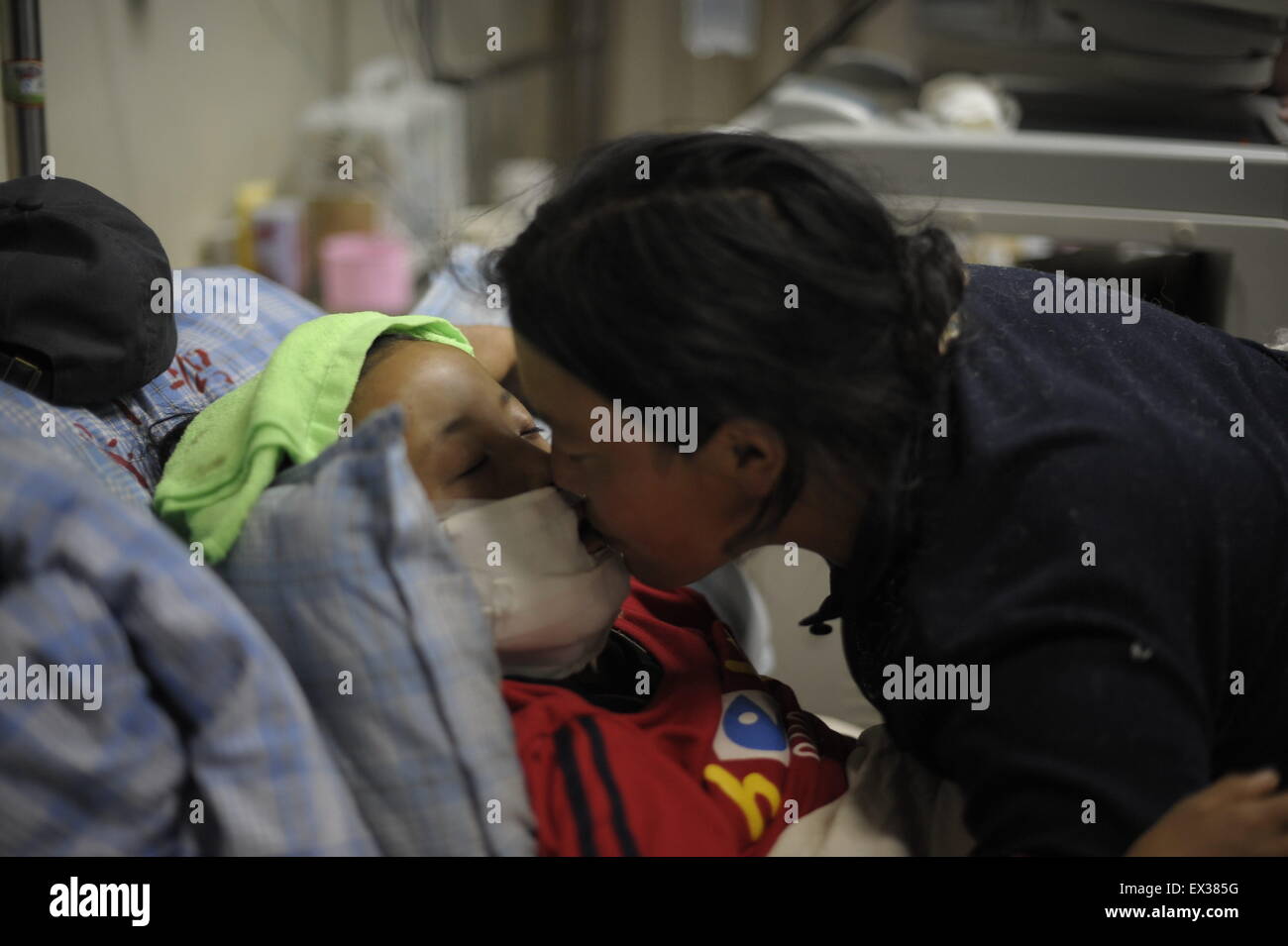 Una madre bacia la sua figlia di 11 anni salvato dalle macerie di una casa distrutta in earthquak-ha colpito la zona in corrispondenza di un ospedale in Hainan, Foto Stock