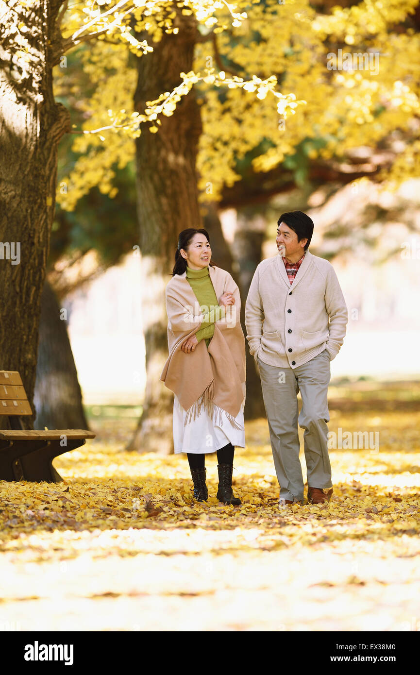 Senior coppia giapponese in un parco della città in autunno Foto Stock