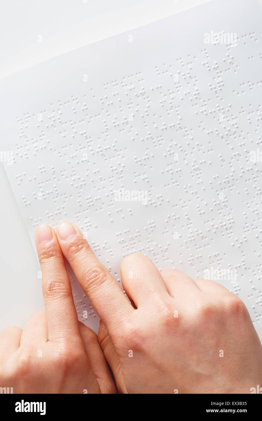 Le mani di lettura carta Braille Foto Stock