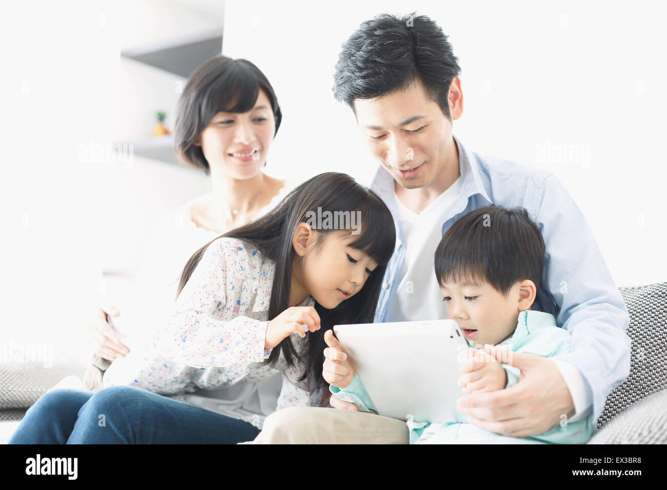 Famiglia giapponese sul divano Foto Stock