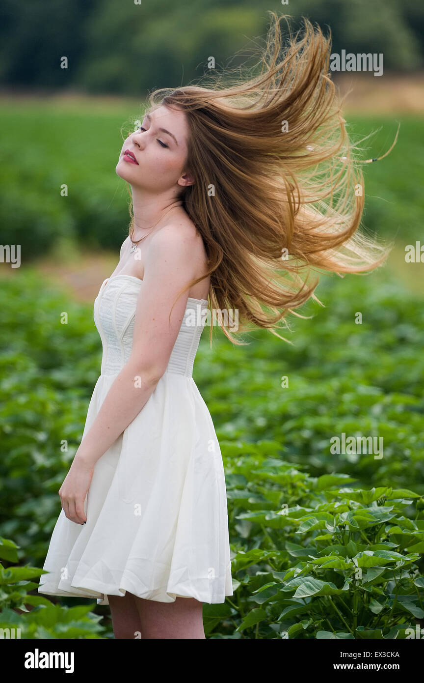 Una giovane donna in un campo verde e i capelli al vento. Kibbutz Ha'solelim, Israele Foto Stock