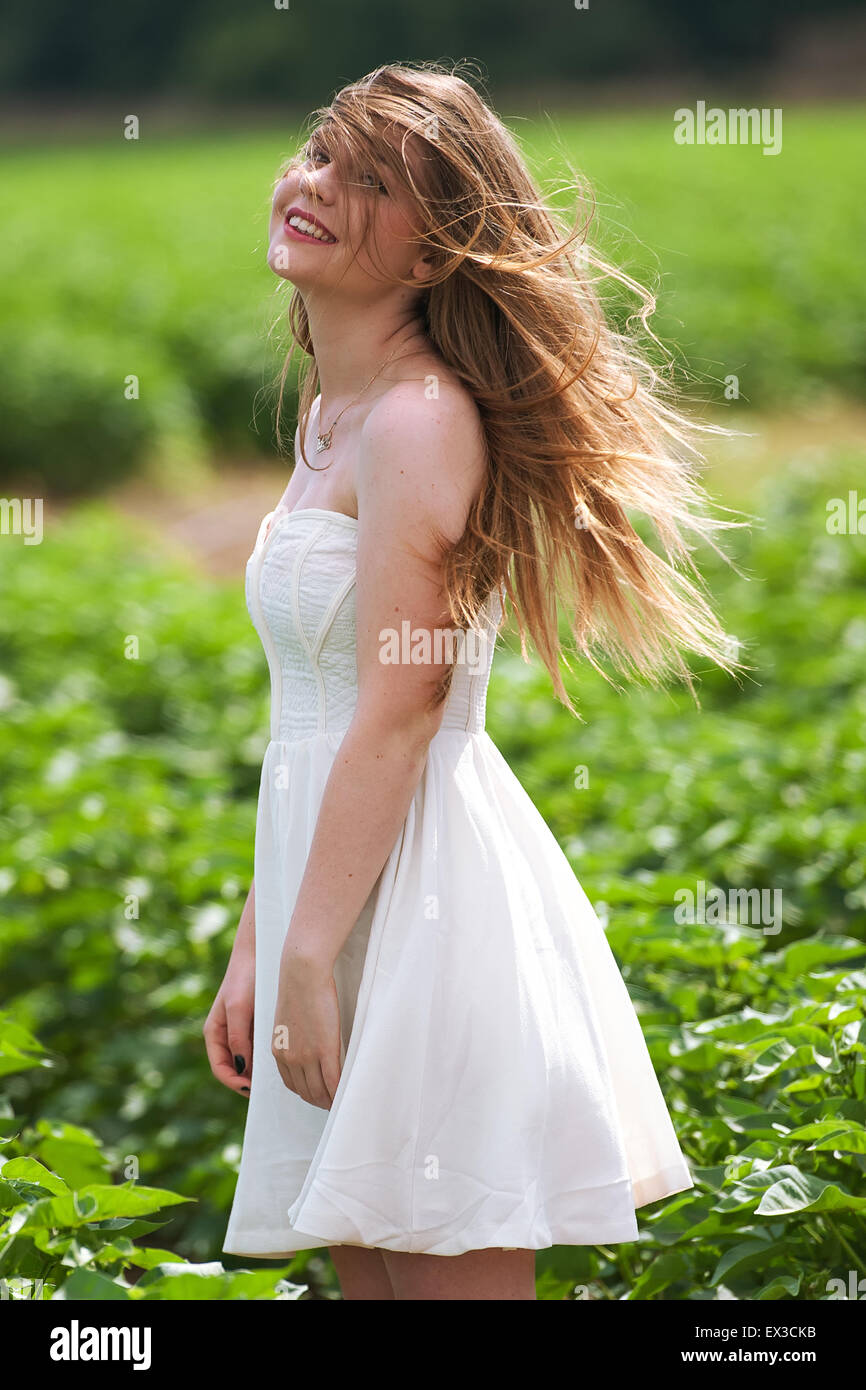 Una giovane donna in un campo verde e i capelli al vento. Kibbutz Ha'solelim, Israele Foto Stock