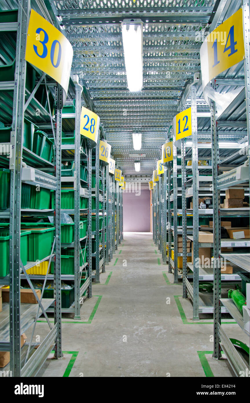 Magazzino con scaffali in acciaio e le caselle verdi Foto Stock