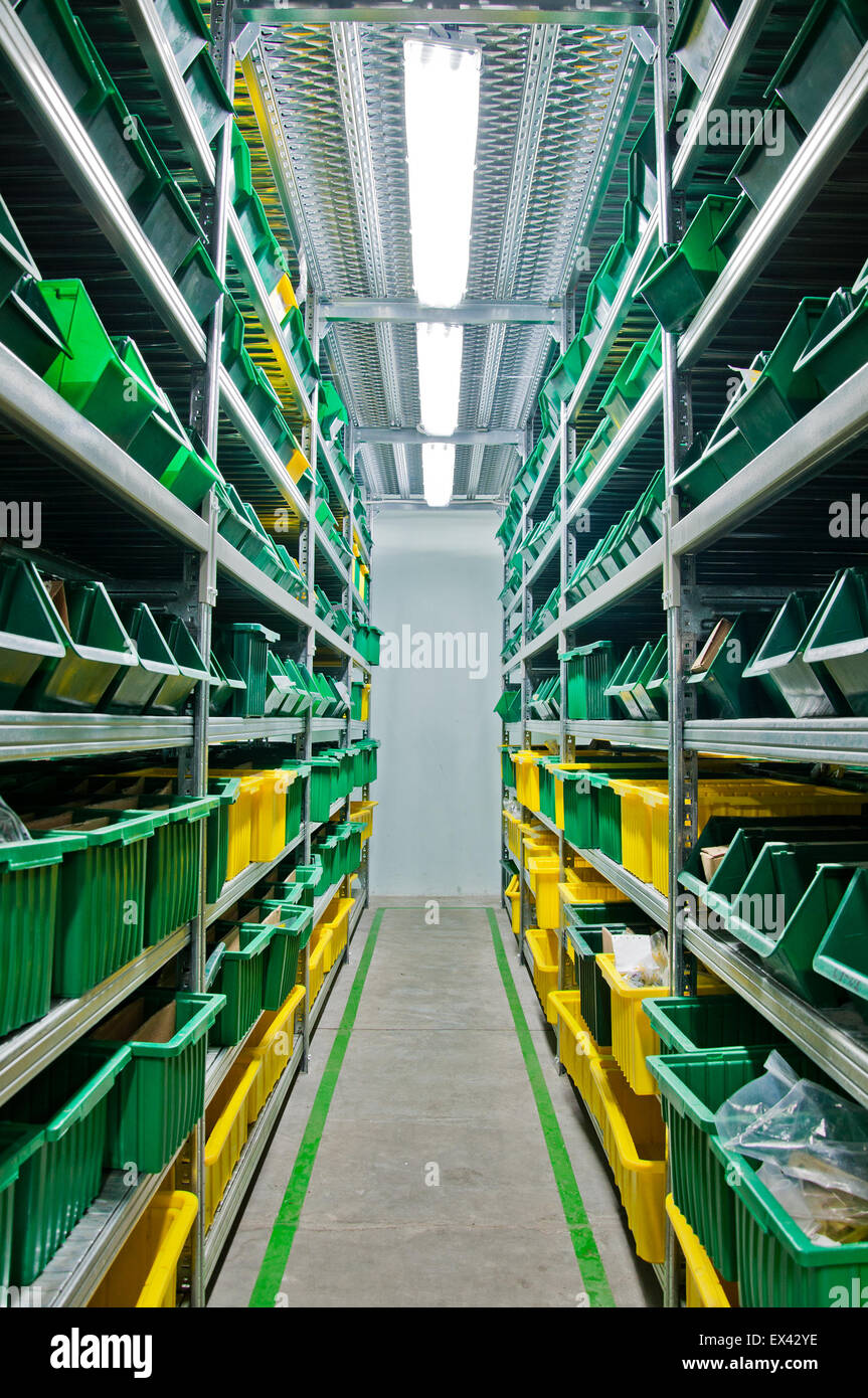 Magazzino con scaffali in acciaio e le caselle verdi Foto Stock