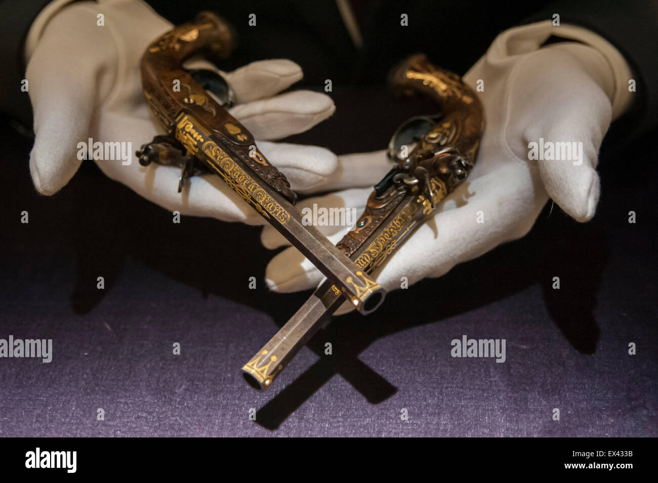 Londra, Regno Unito. 6 luglio 2015. Un Sotheby's tecnico mostra una coppia di valorizzazione su misura gold-incrostati di pistole realizzato dal celebre armaiolo Jean Lepage per Napoleone in tre anni di vecchio figlio (est. £800k a £1,2m) in anteprima di Vecchi Maestri, British dipinti e Capolavori dalla collezione di Castle Howard da Sotheby's davanti all'asta su luglio 8. Credito: Stephen Chung / Alamy Live News Foto Stock