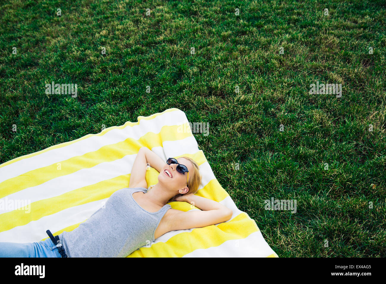 Felice giovane ragazza in appoggio sul prato all'aperto Foto Stock