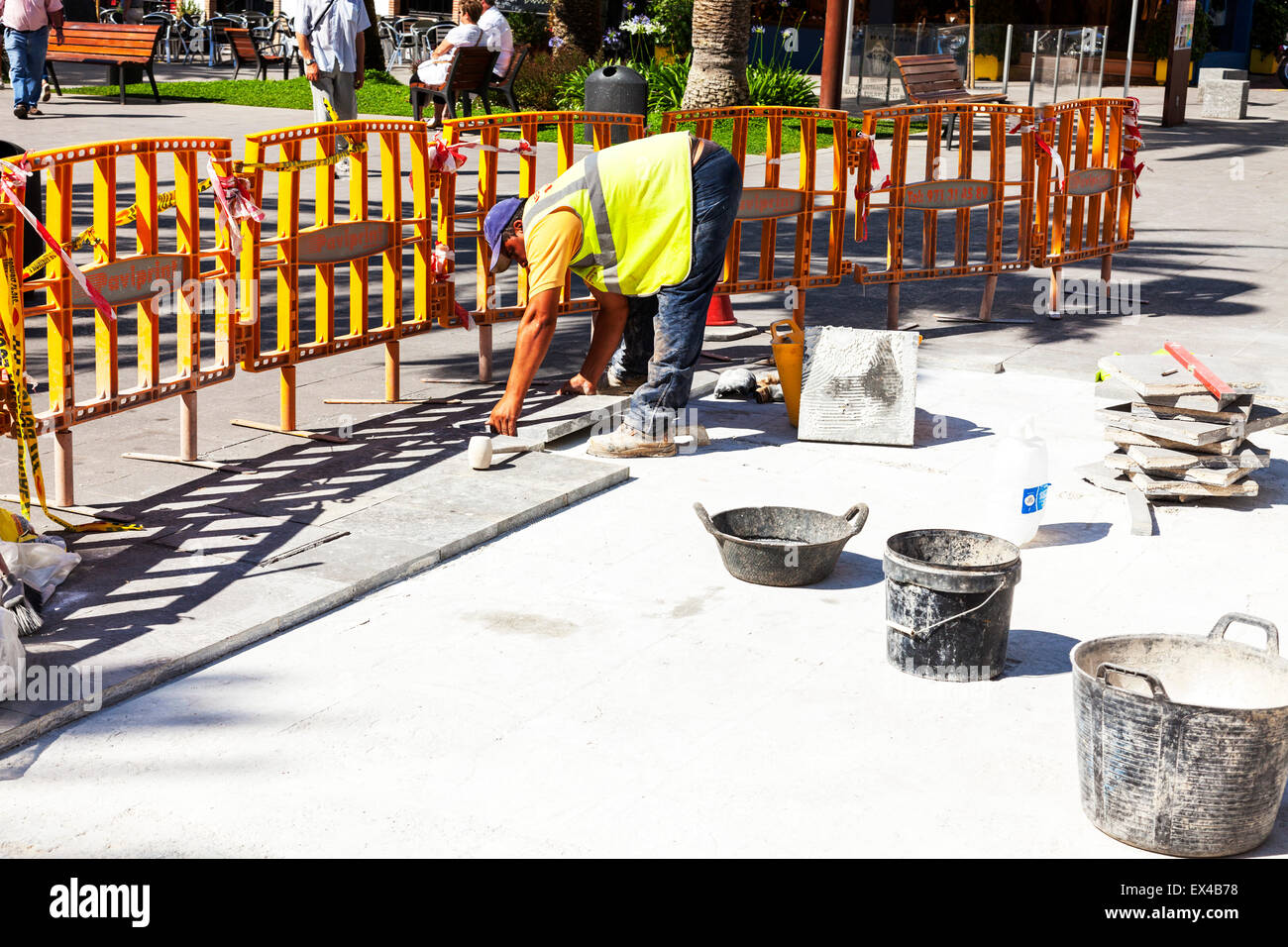 L'uomo la posa di pietre per pavimentazione in lastre mattoni lavorano patio percorso di curvatura di raccordo su Foto Stock