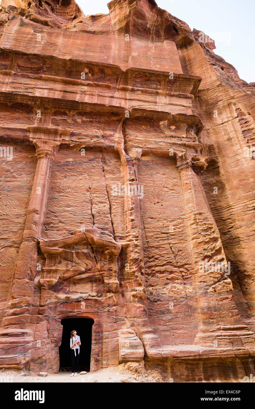 Petra, Giordania, 8 giugno. Turista femminile guarda da un portale scolpito nella roccia di Petra in Giordania. Foto Stock