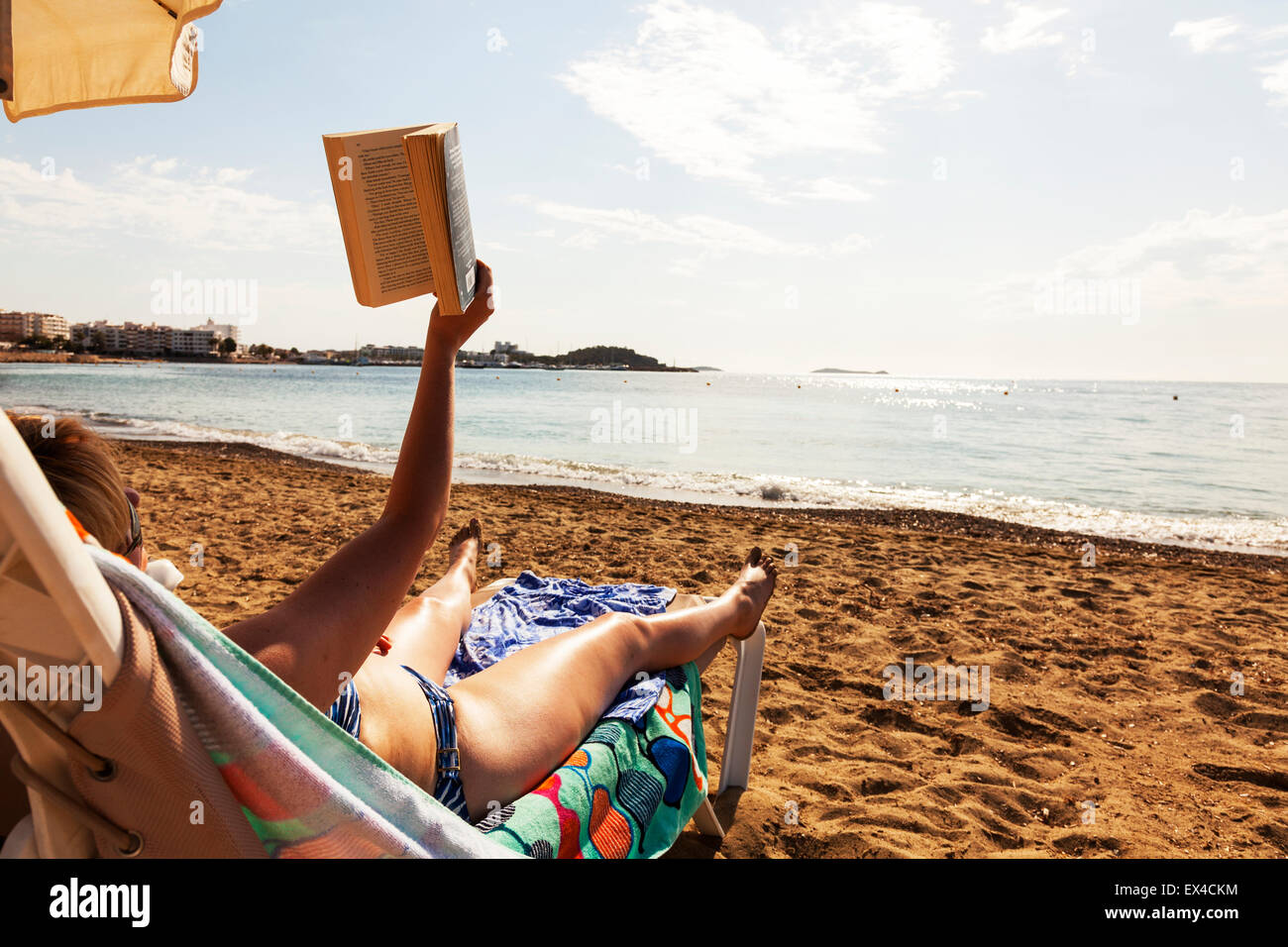 La lettura di un libro sul vacanza sulla spiaggia sdraio leggere accanto al  mare costiero della costa casa vacanza vacanze Foto stock - Alamy