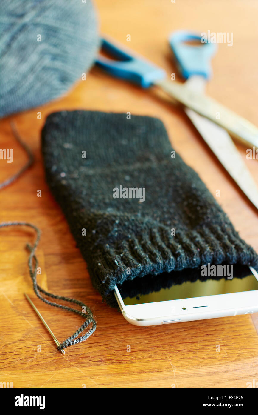Smartphone moderno in un caso ha fatto da un vecchio calzino. Foto Stock