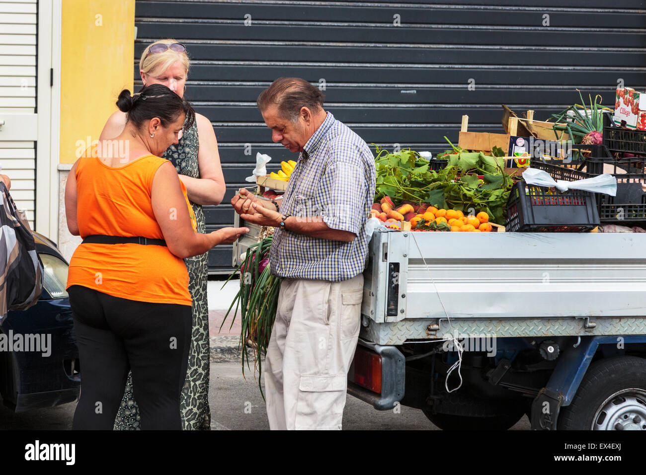 Donna acquistare frutta e verdura fresca da un venditore ambulante, Sicilia, Italia Foto Stock