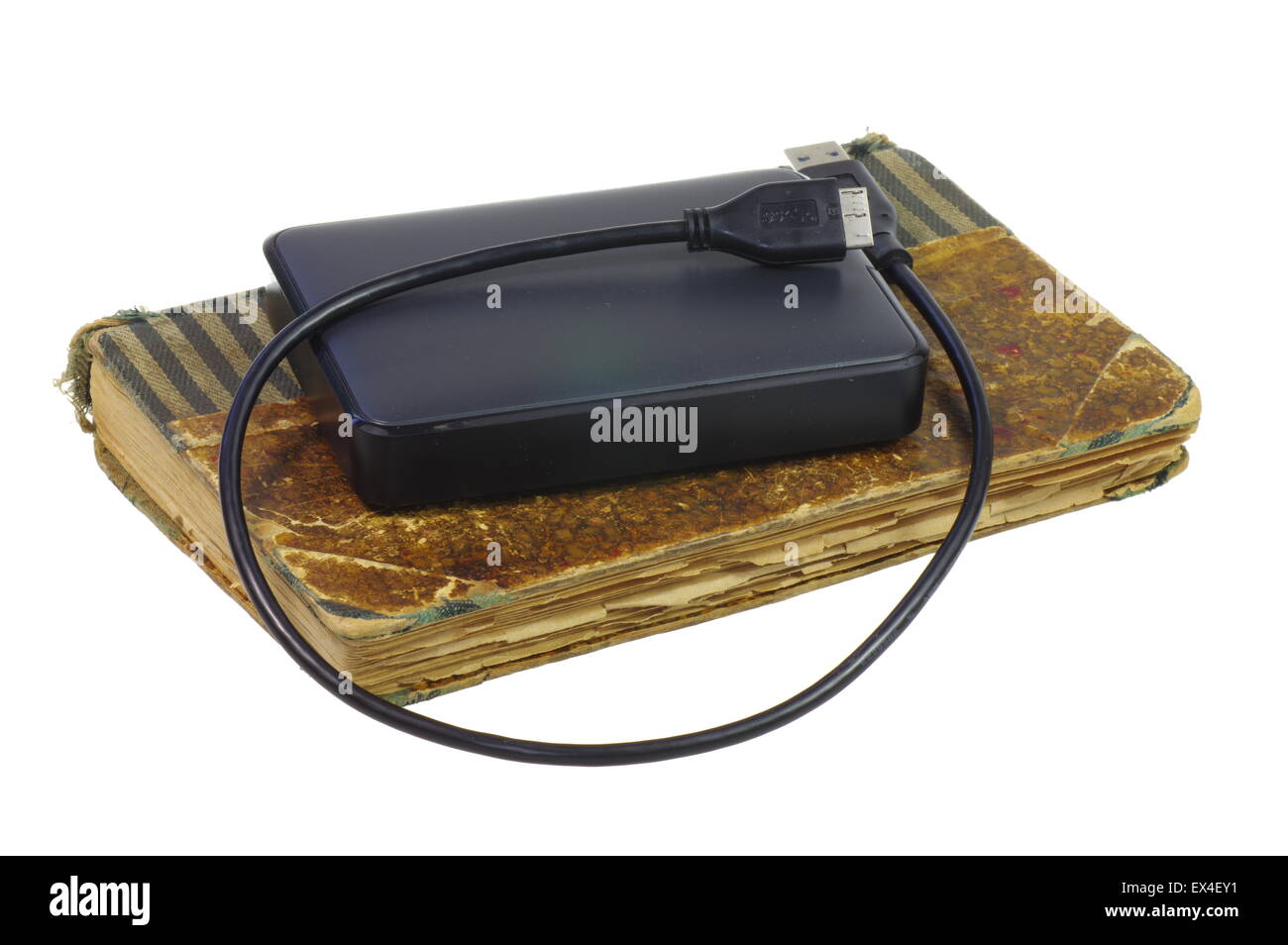 La memoria esterna. Computer esterno disk giacente su un vecchio libro. Sullo sfondo bianco, isolata. Foto Stock