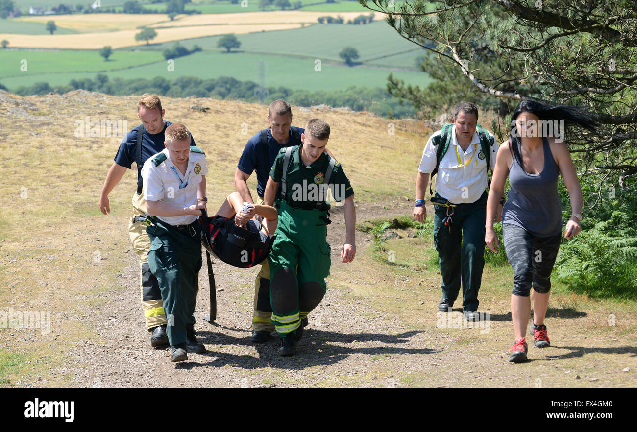 Shropshire servizio ambulanza e Shropshire Incendio e salvataggio ufficiali trasportare feriti donna torna in ambulanza Wrekin Hill Regno Unito Foto Stock