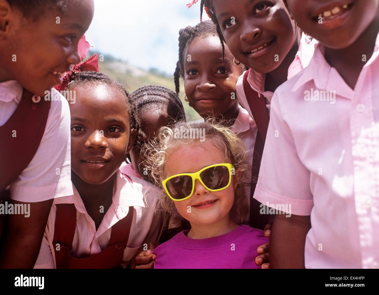 Caraibi, Isole Vergini Britanniche, Tortola, il turista caucasico incontra i bambini delle scuole afroamericane Foto Stock