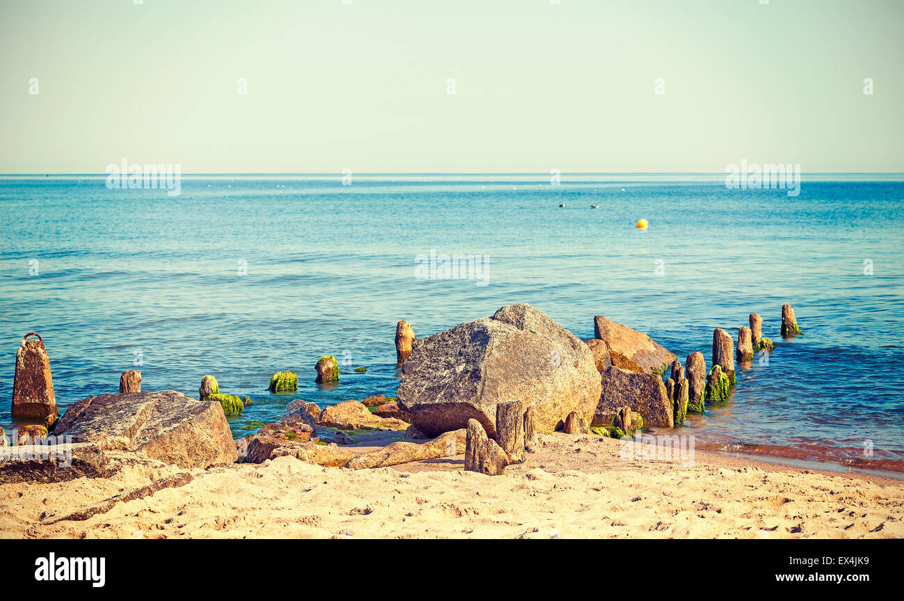 Retrò tonica rocce e posti di legno sulla spiaggia, estate natura dello sfondo. Foto Stock
