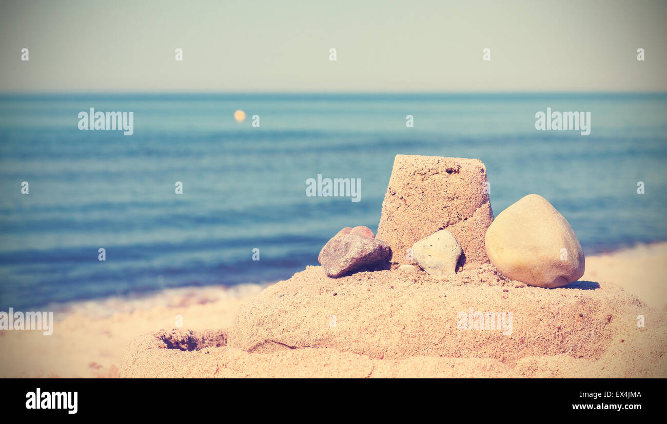 Vintage retrò tonica semplice sandcastle su una spiaggia, vacanze estive concetto. Foto Stock