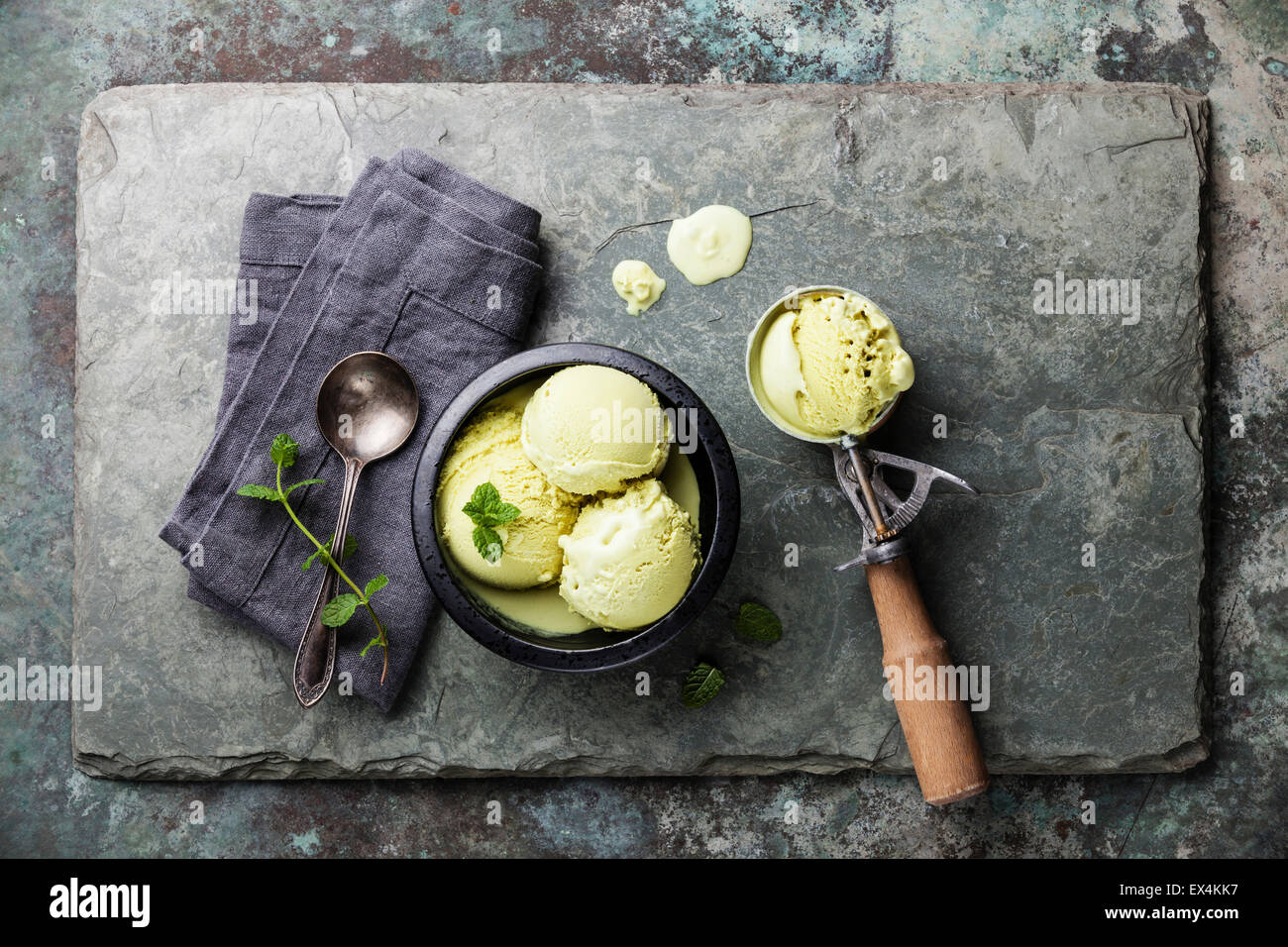 Il tè verde gelato con foglie di menta e cucchiaio per gelato su pietra ardesia sfondo Foto Stock