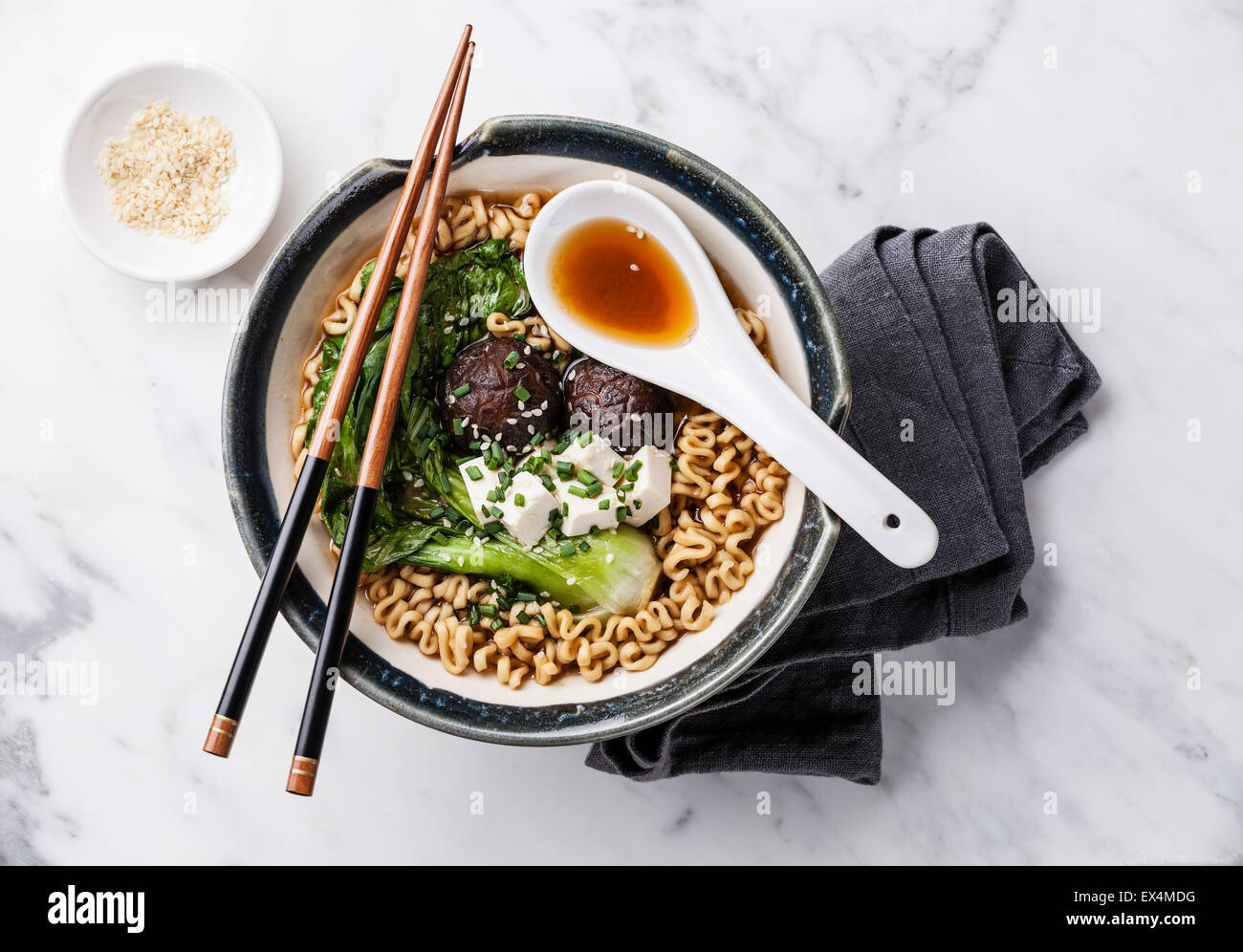 Miso Ramen Asian tagliatelle con i funghi shiitake, tofu e cavolo pak choi in ciotola su marmo bianco sullo sfondo Foto Stock