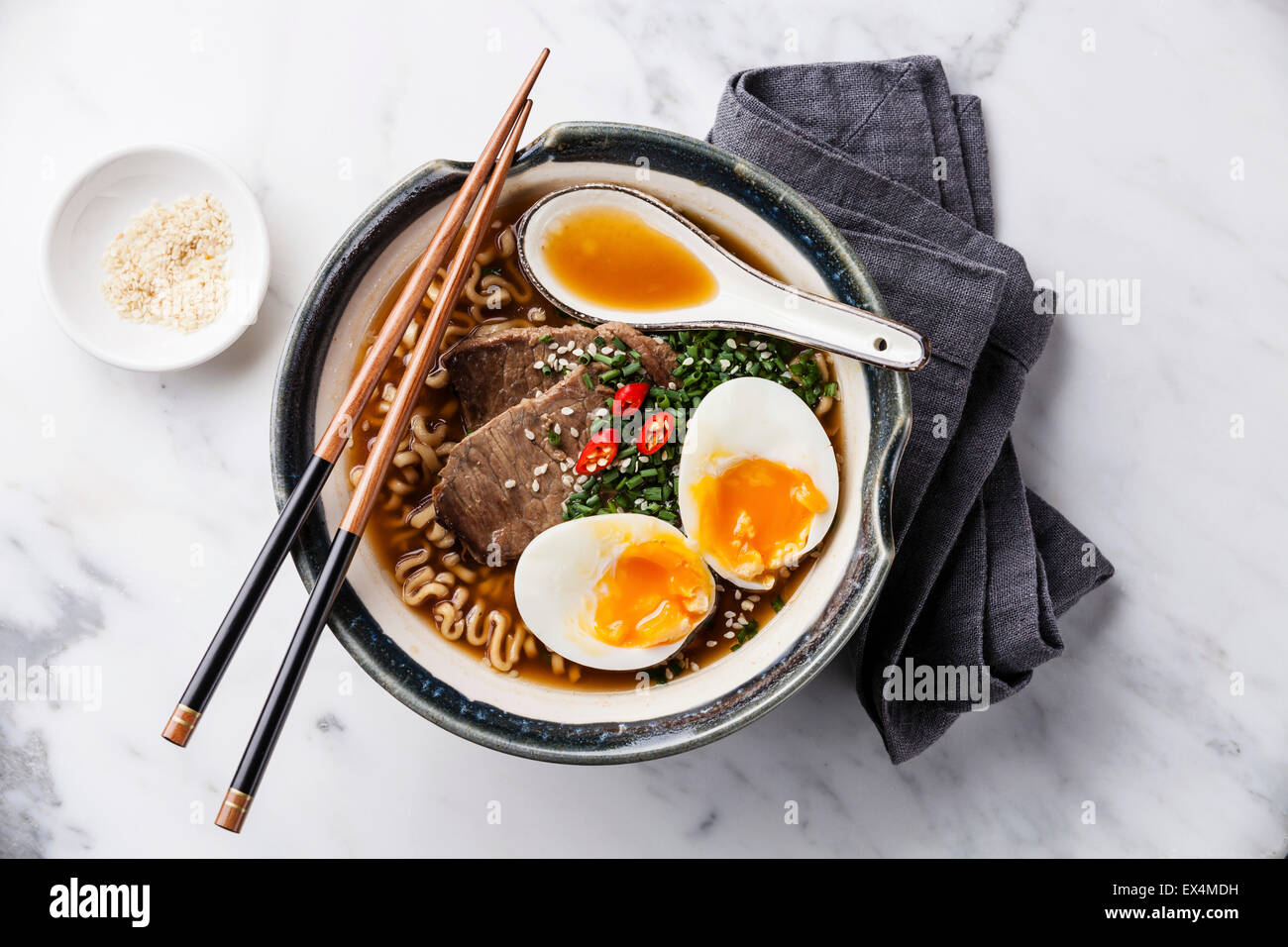 Miso Ramen noodle asiatici con la carne e le uova in una terrina su marmo bianco sullo sfondo Foto Stock