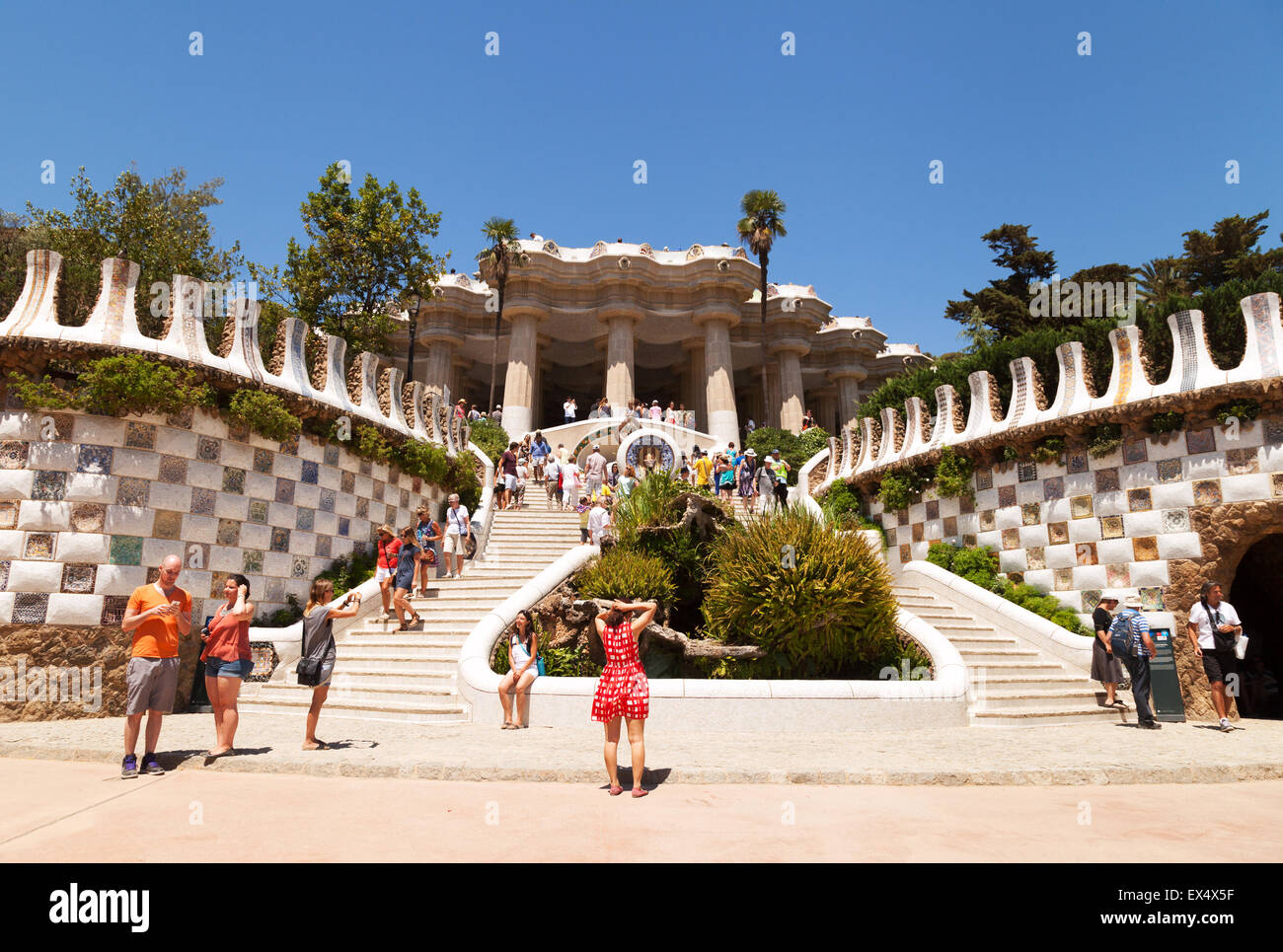 I turisti guardando la scala, Gaudi Parco Guell, sito patrimonio mondiale dell'UNESCO, Barcelona, Spagna Europa Foto Stock