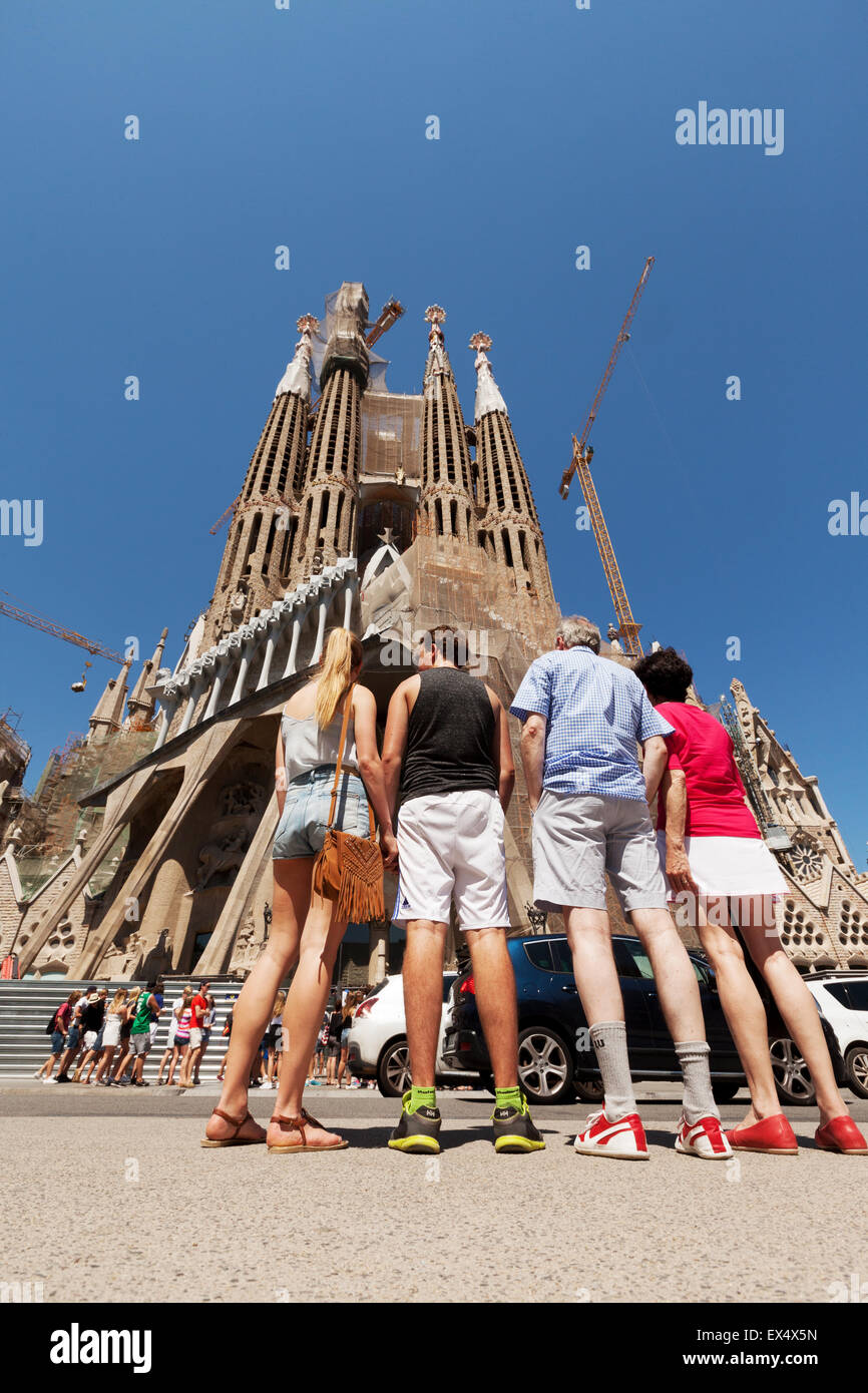 Un turista la famiglia presso la Basilica della Sagrada Familia di Gaudi, sito patrimonio mondiale dell'UNESCO, Barcelona, Spagna Europa Foto Stock