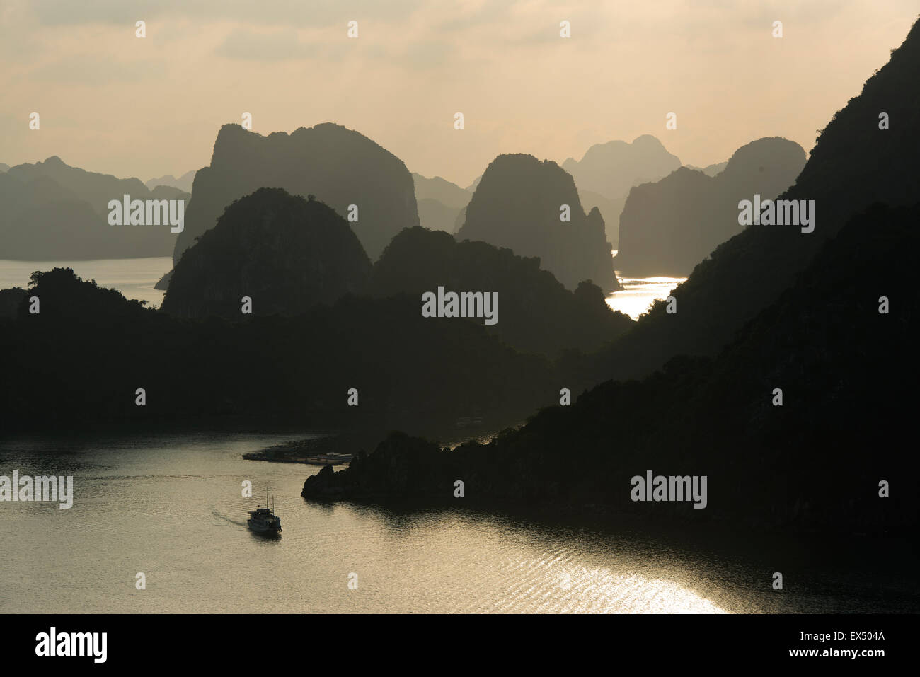 Barca in acqua al tramonto nella Baia di Ha Long o Vinh Ha Long, scogliere calcaree, Sito Patrimonio Mondiale dell'UNESCO, Golfo del Tonchino Foto Stock