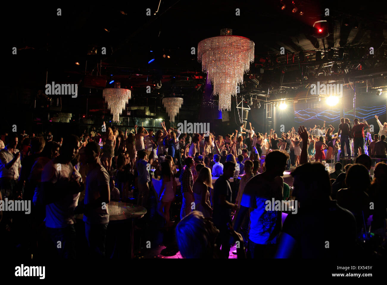 Accesa lampadari e clubber's dancing shilhouetted corpi in background, in un nightclub greco. Atene, Grecia. Foto Stock