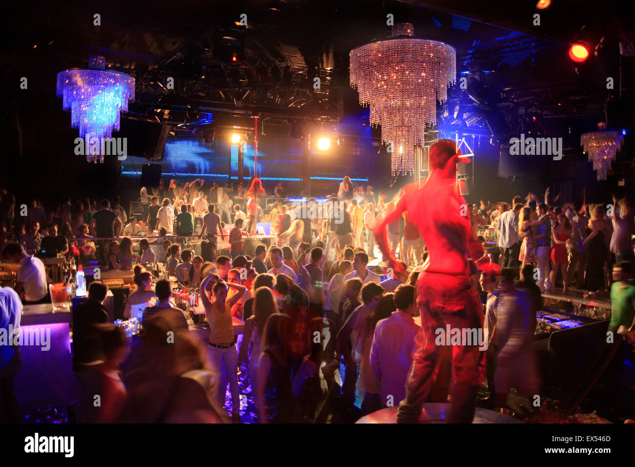 Abbagliante acceso lampadari e clubber di corpi di ballo in background, in un nightclub greco. Atene, Grecia. Foto Stock