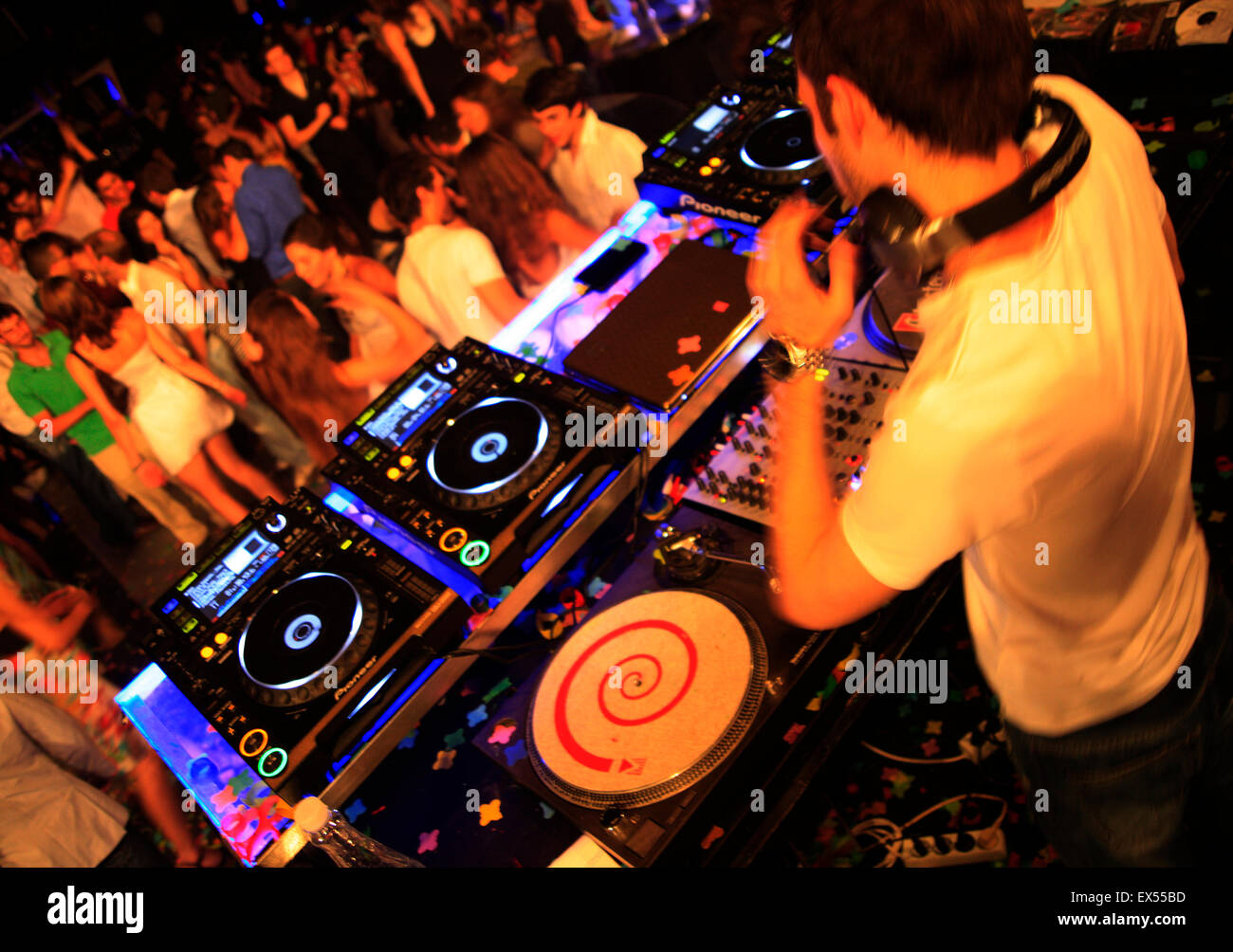 DJ sui ponti audio / dispositivi di miscelazione e dancing clubbers. Il nightclub di Atene, Grecia. Foto Stock