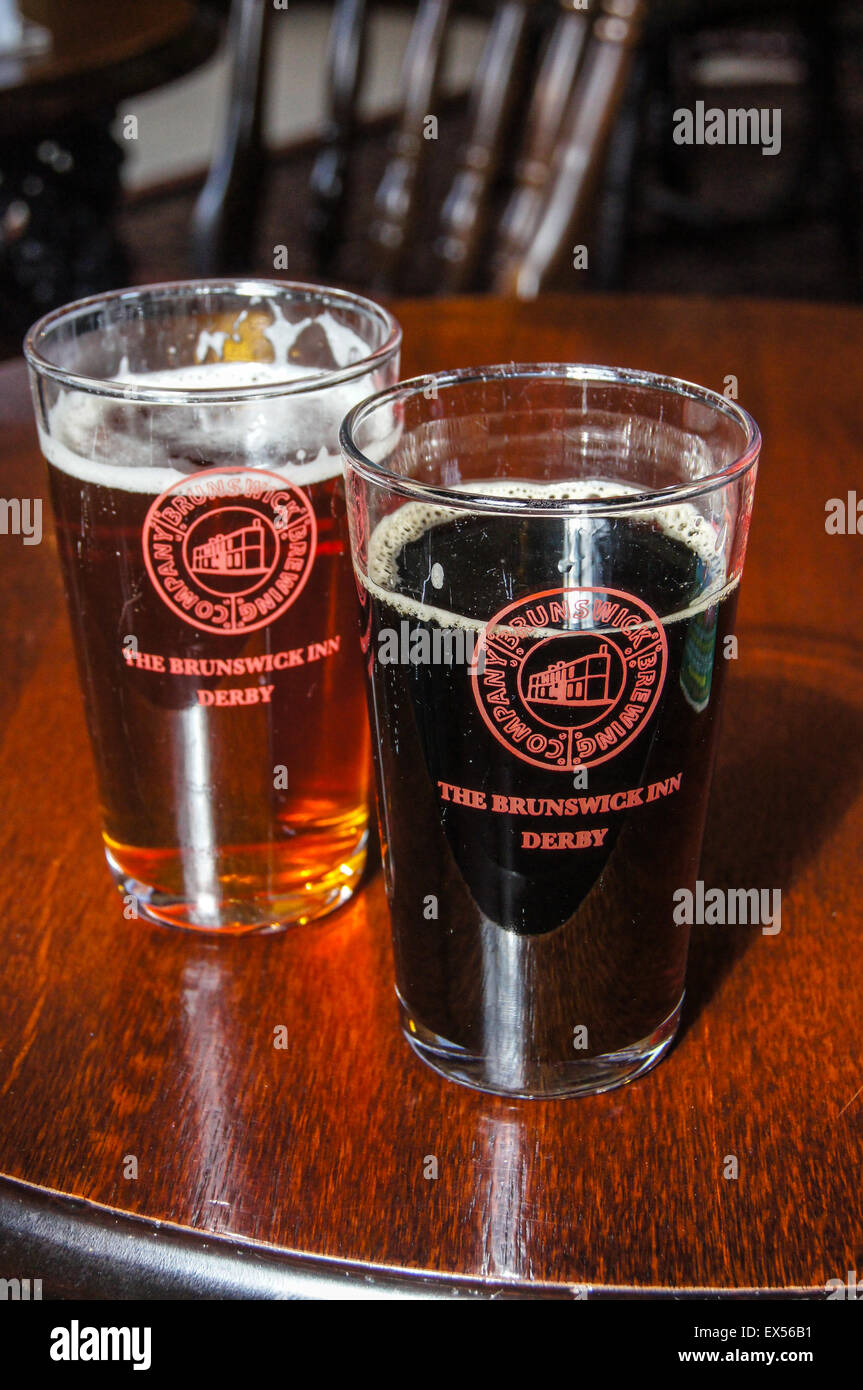 Una mezza pinta di vetro " consueto' amaro di rame e "Ferrovia Porter' ale, Brunswick Inn, , Derby Derbyshire, Inghilterra pub tavola bicchieri di bevande Foto Stock