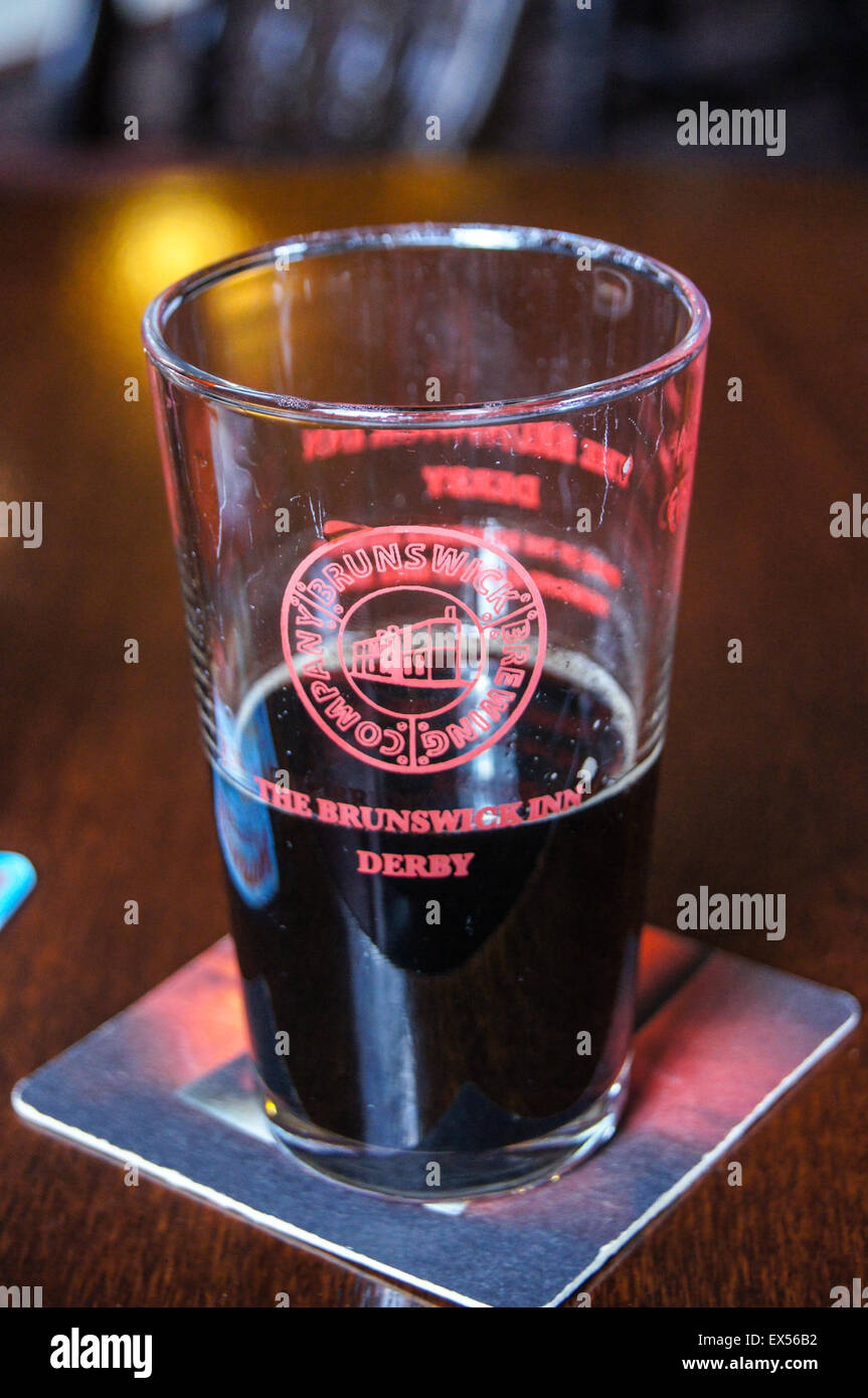Una mezza pinta di vetro "Ferrovia Porter' ale, Brunswick Inn, ferroviaria terrazza, Derby, Derbyshire, Inghilterra pub tavola bicchieri di bevande Foto Stock