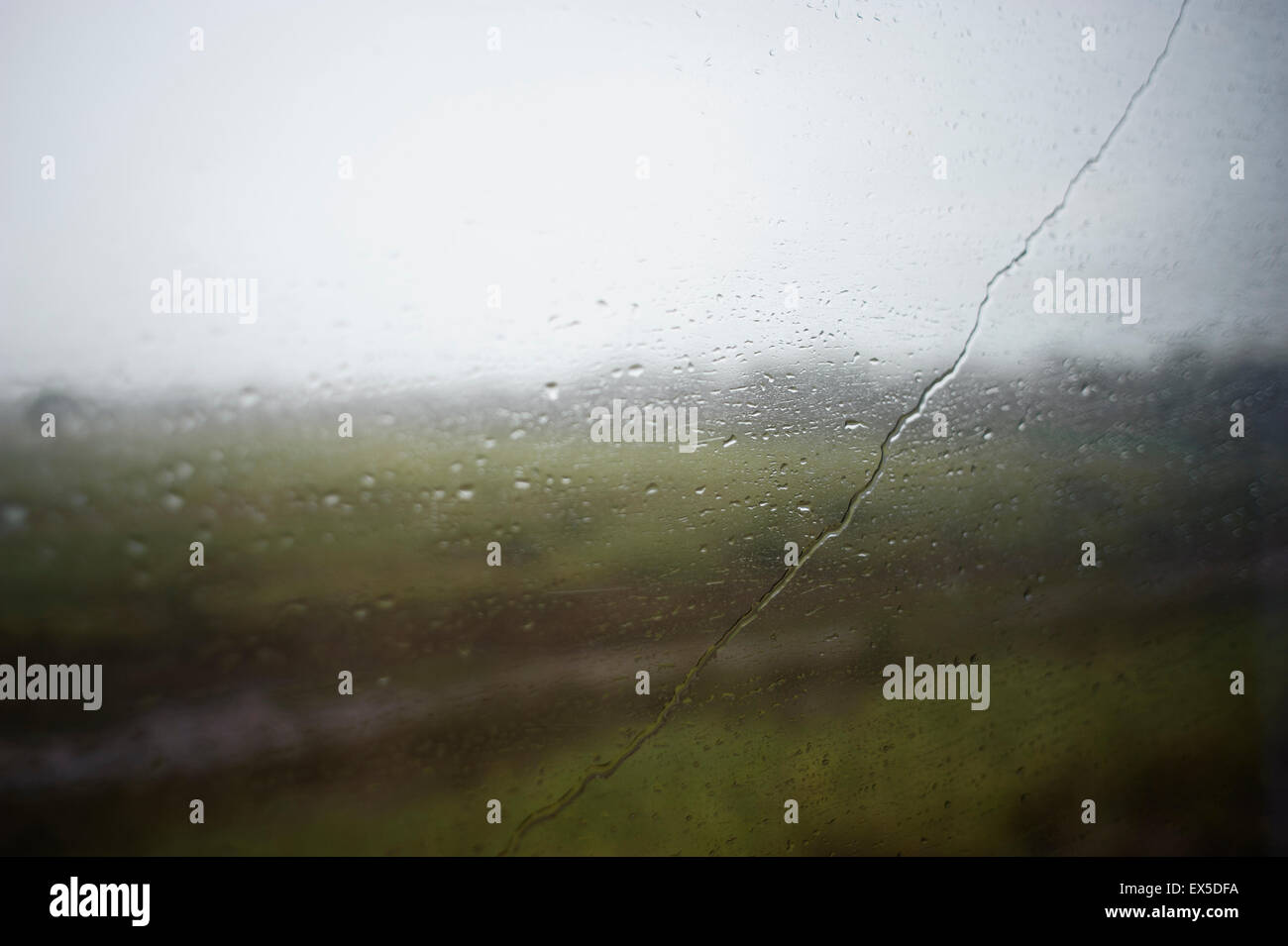 Gocce di pioggia su una finestra di bus Foto Stock