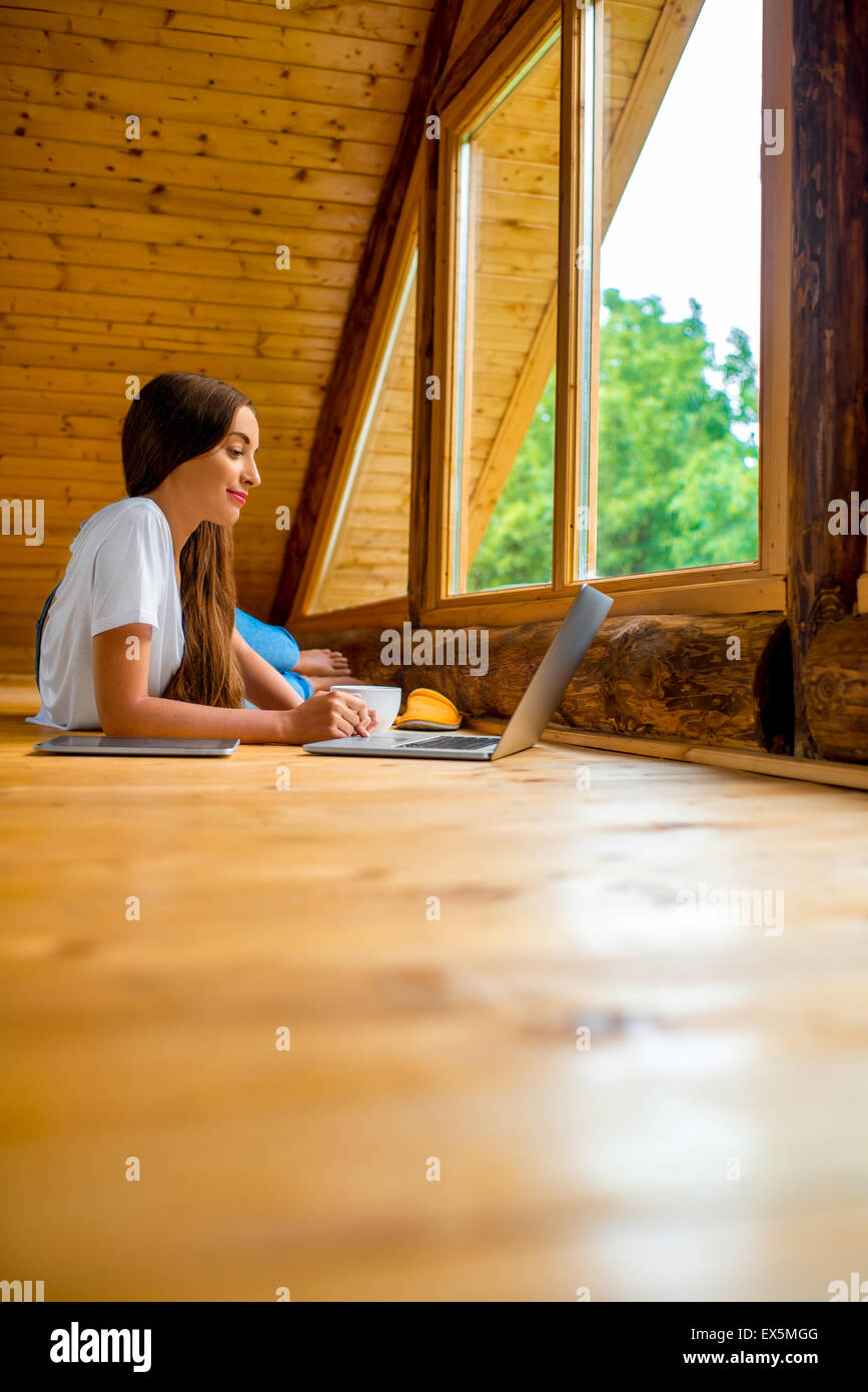 Donna rilassante in casa in legno Foto Stock