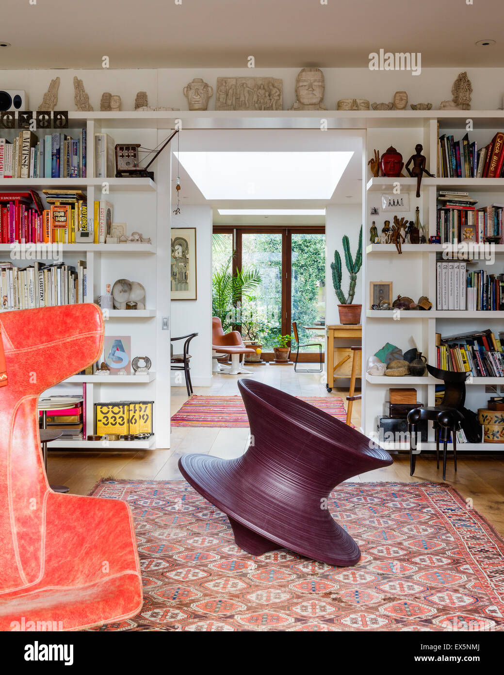 Round chair di Thomas Heatherwick in sala da disegno con incorporato di libro scaffali e tappeti marocchini. Il teste scolpite sono da Eduard Foto Stock