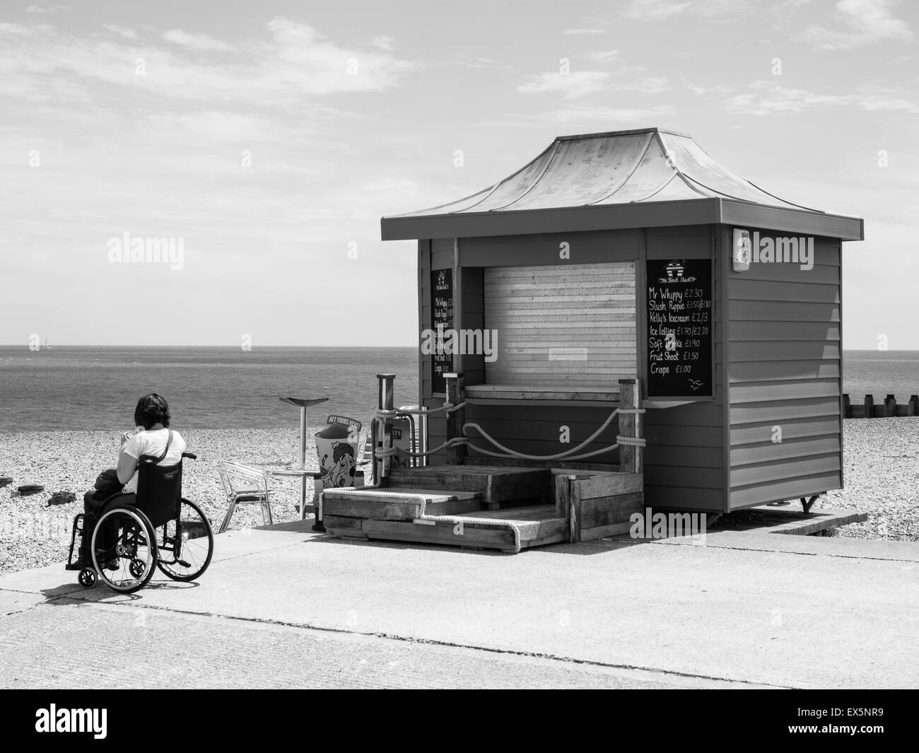 Donna disabile in carrozzella sul lungomare di Eastbourne Foto Stock