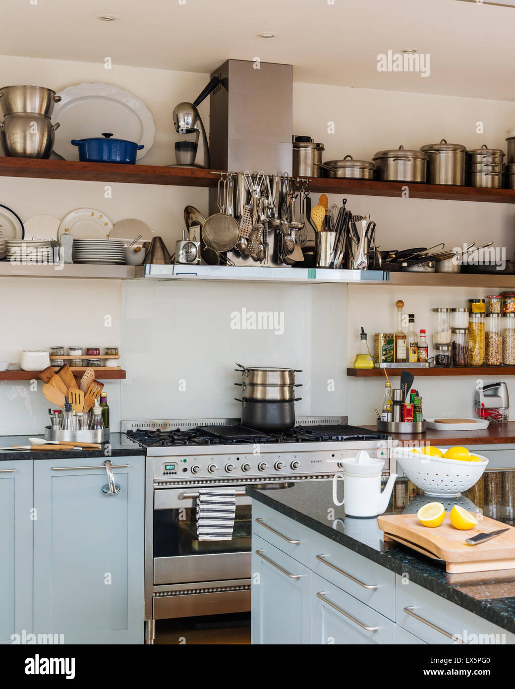 Scaffali aperti in bright ariosa cucina con fornello e ripiano in granito superfici di lavoro Foto Stock