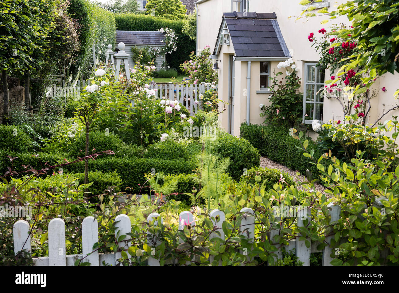 La facciata esterna di un paese di lingua inglese cottage con Picket Fence e il giardino delle rose Foto Stock