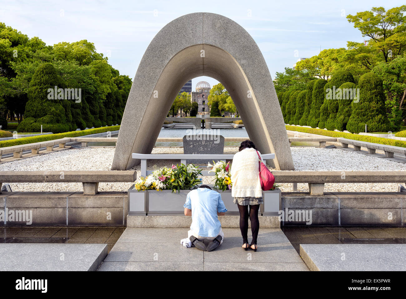Hiroshima, Giappone - 27 Aprile 2014: vista di una giovane giapponese in preghiera di fronte il Cenotafio nel Parco della Pace. Foto Stock
