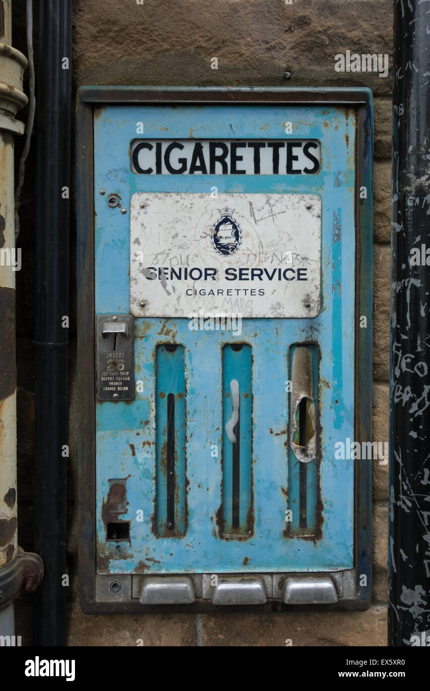 In disuso Servizio Senior sigaretta macchina distributrice sul muro di pietra in Viewfield Street, Stirling, Scozia, Regno Unito Foto Stock