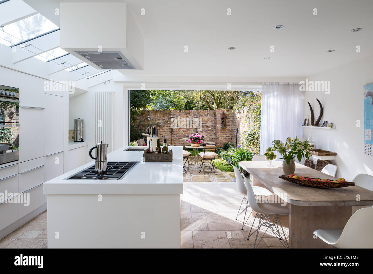 Aprire il piano bianco cucina moderna con custom made tabella di calce e legno di quercia e di plastica sedie Eames Foto Stock