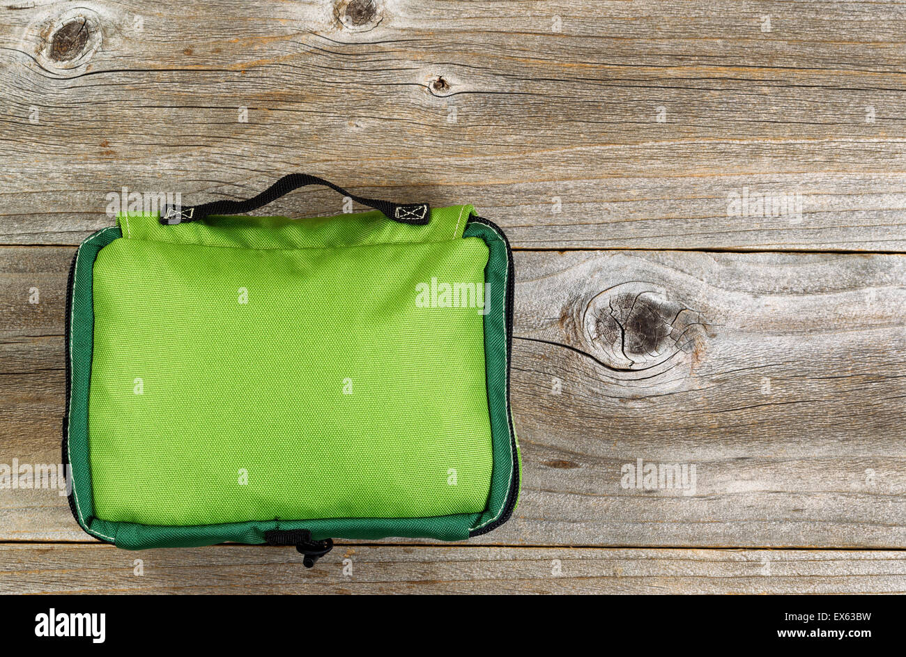Vista dall'alto il colpo di un impermeabile in nylon kit medici sacchetto esterno per viaggiare su rustiche tavole in legno. Foto Stock