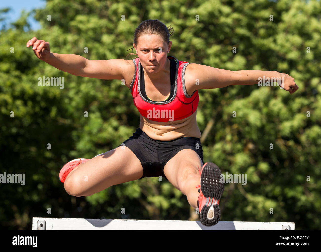 Giovane donna, 20 anni, hurdling Foto Stock