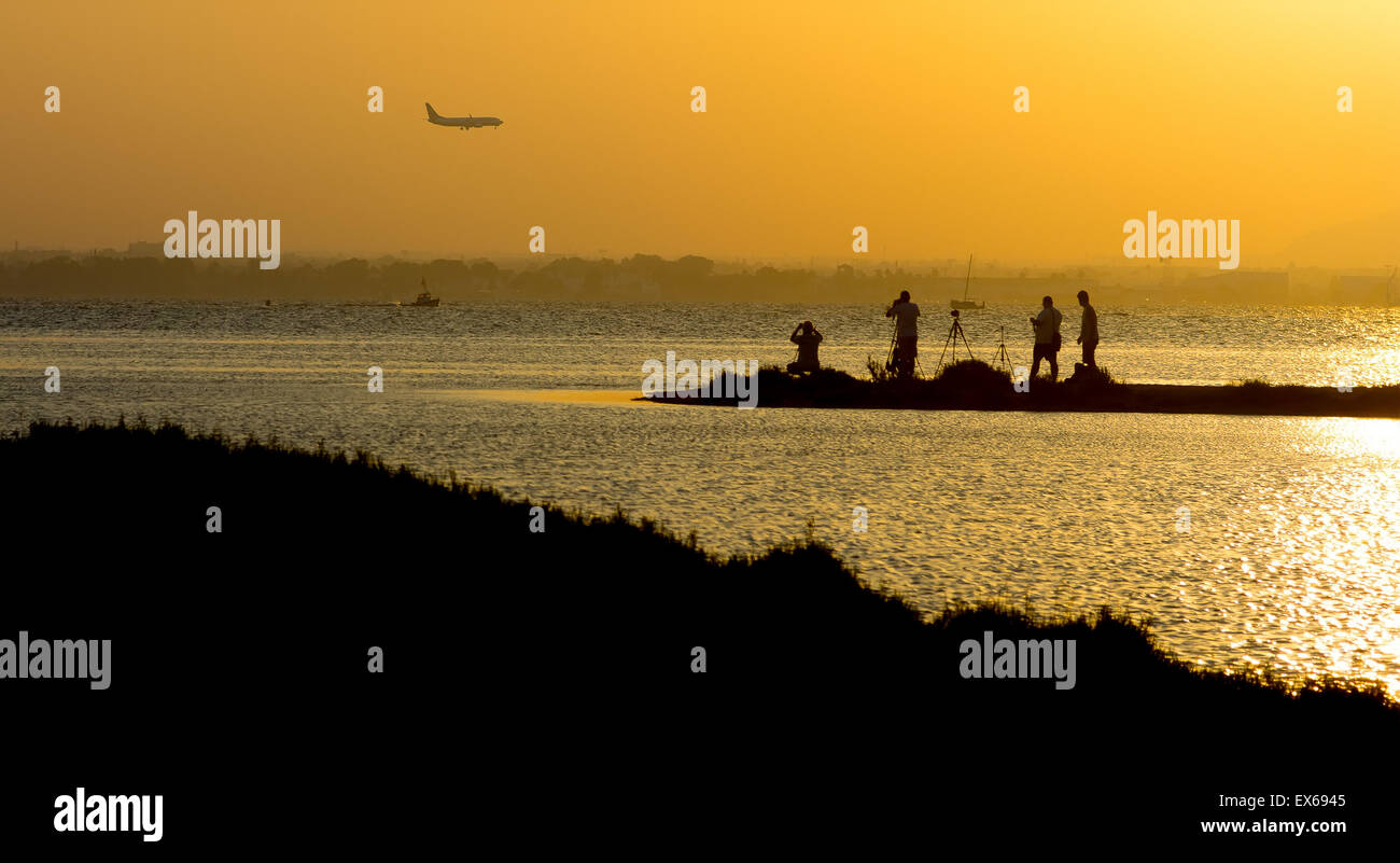Persone piani di fotografia dal mare al tramonto Foto Stock