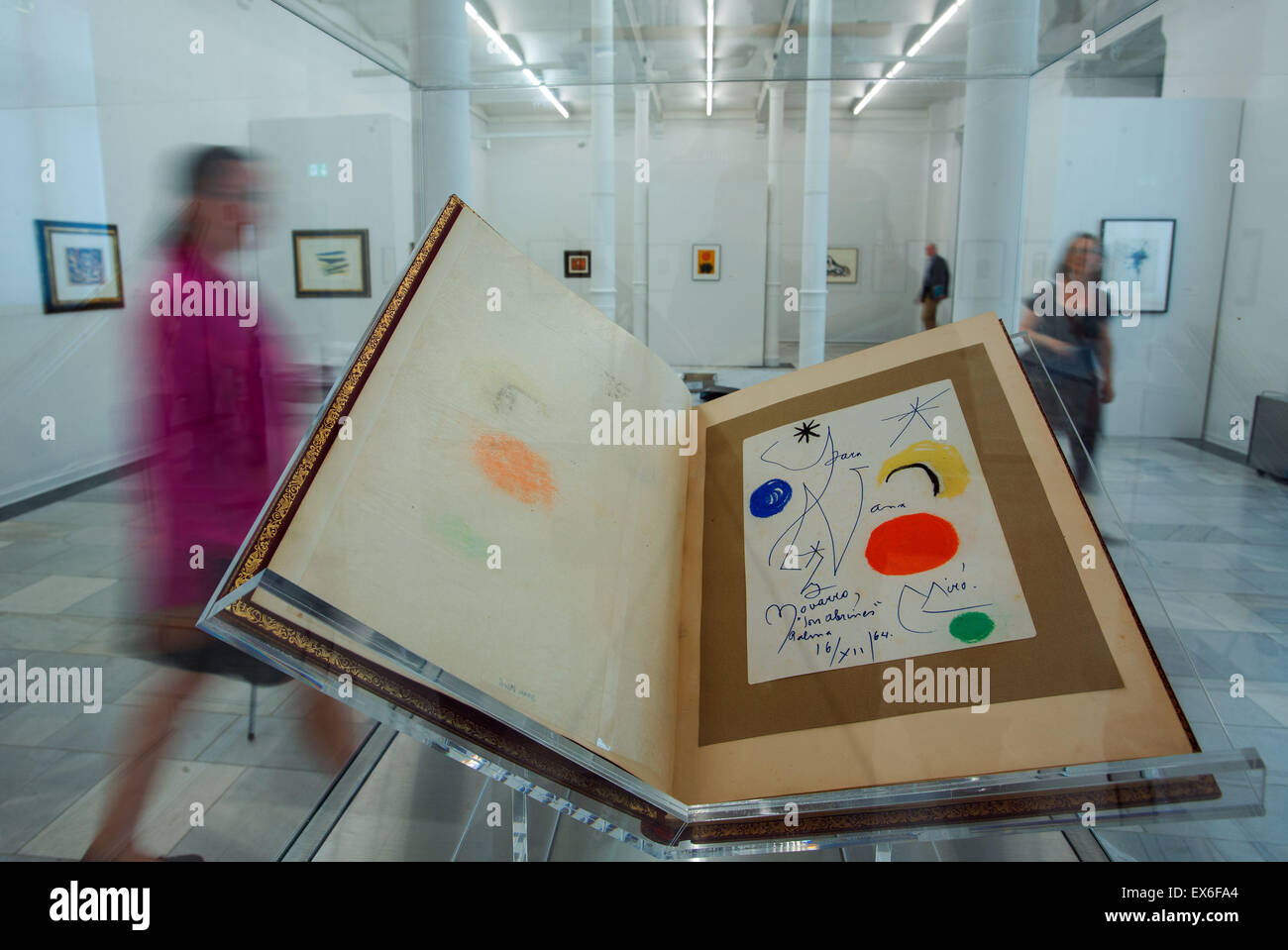 Schwerin, Germania. 08 Luglio, 2015. I visitatori a piedi passato un disegno di Joan Miro dal 1964 che viene visualizzato nel carnet d' o (lit. Libro d'oro) del ritratto fotografo Eddy Novarro nella mostra 'caleidoscopio di epoca moderna' nel museo di stato di Schwerin, Germania, 08 luglio 2015. Questa estate il museo espone opere di diversi movimenti artistici come il classico era moderna e pop art. Tutte le opere presentate sono parte della collezione del fotografo Eddy Novarro (1925-2003) che ha raccolto le opere d'arte e fotografato i rispettivi artisti. Foto: Jens BUETTNER/dpa/Alamy Live News Foto Stock